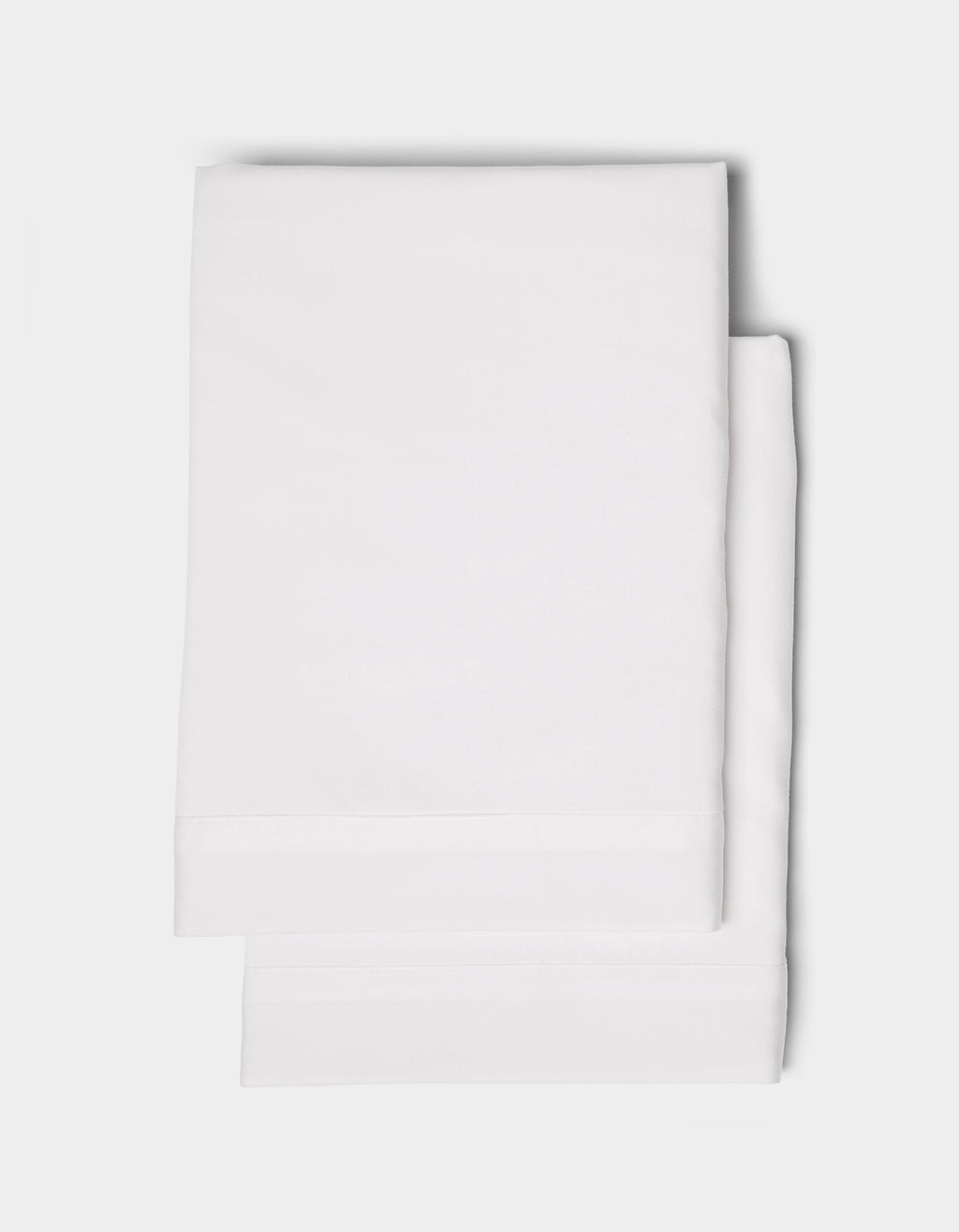 Two neatly folded Cozy Earth Soft-Wash Cotton Shams stacked on a plain white background.|Color:White