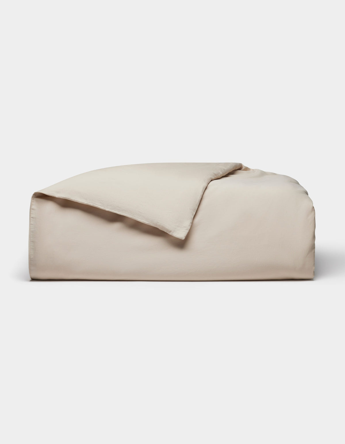 The Cozy Earth Soft-Wash Cotton Duvet Cover, in light beige, is neatly folded with one corner partially flipped over and displayed against a plain white background.|Color:Driftwood