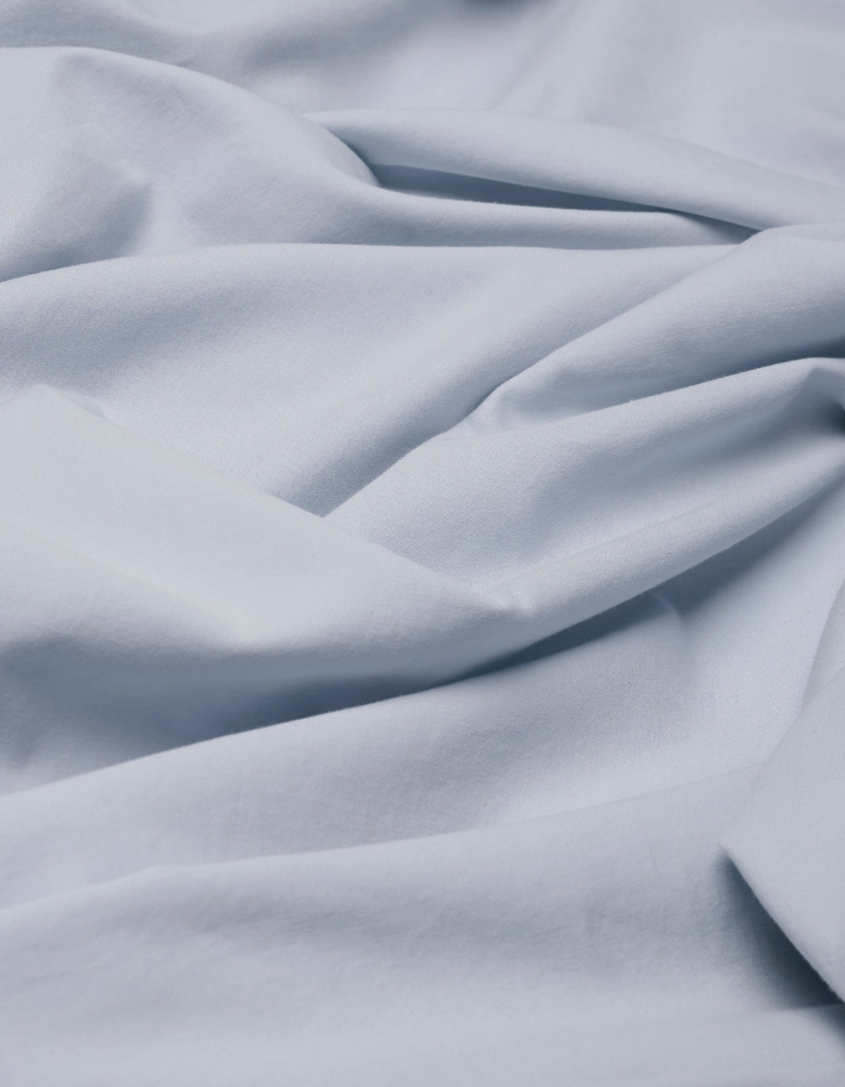 Close-up of Cozy Earth's Soft-Wash Cotton Duvet Bundle in light blue, featuring gentle folds and creases for a smooth, textured appearance.|Color:Shore