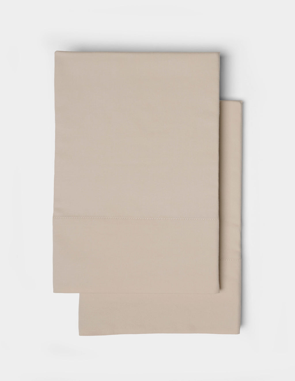 A neatly folded pair of Cozy Earth Soft-Wash Cotton Pillowcases is stacked on a white background, highlighting their smooth fabric and minimalist design.|Color:Driftwood