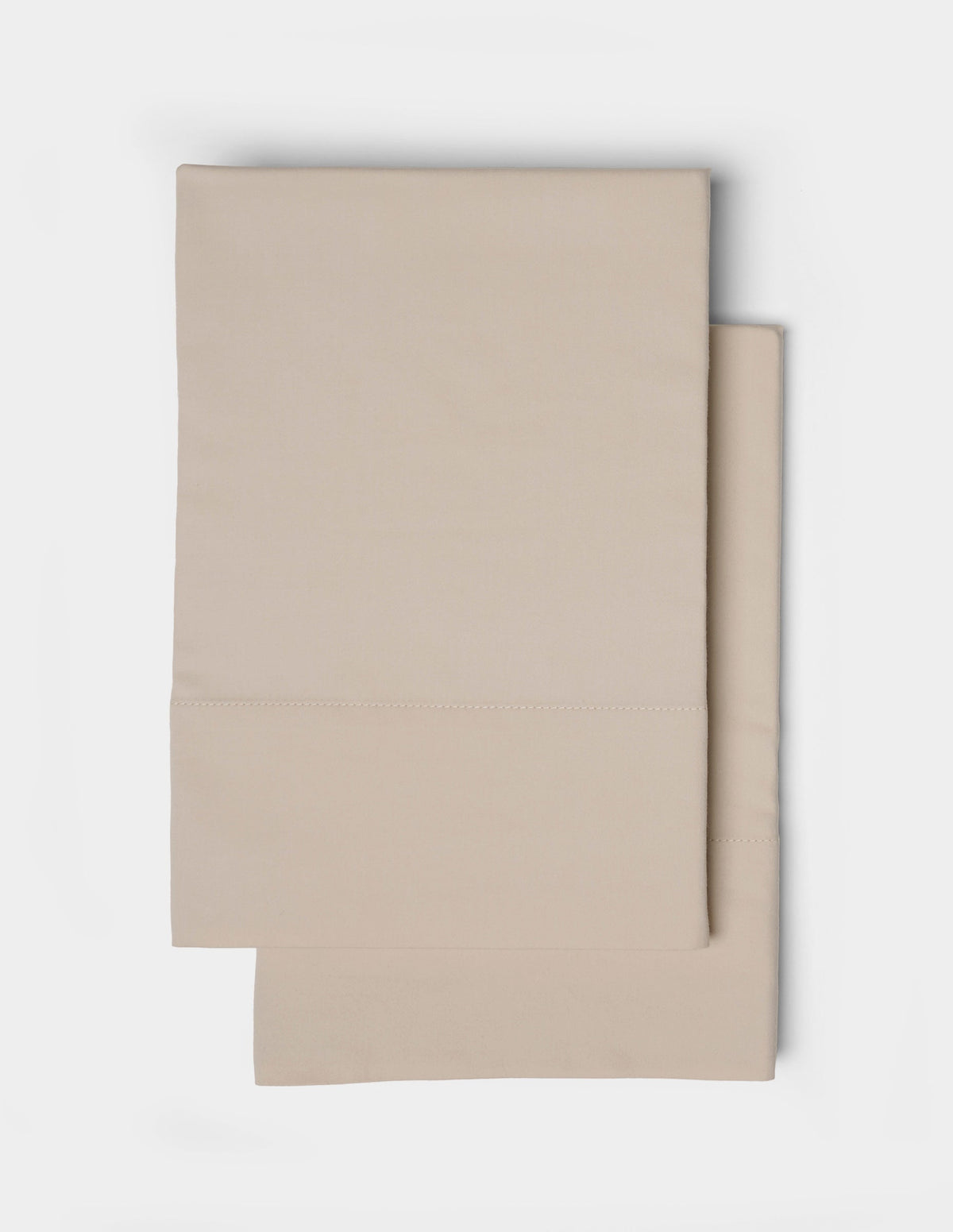 A neatly folded pair of Cozy Earth Soft-Wash Cotton Pillowcases is stacked on a white background, highlighting their smooth fabric and minimalist design.|Color:Driftwood