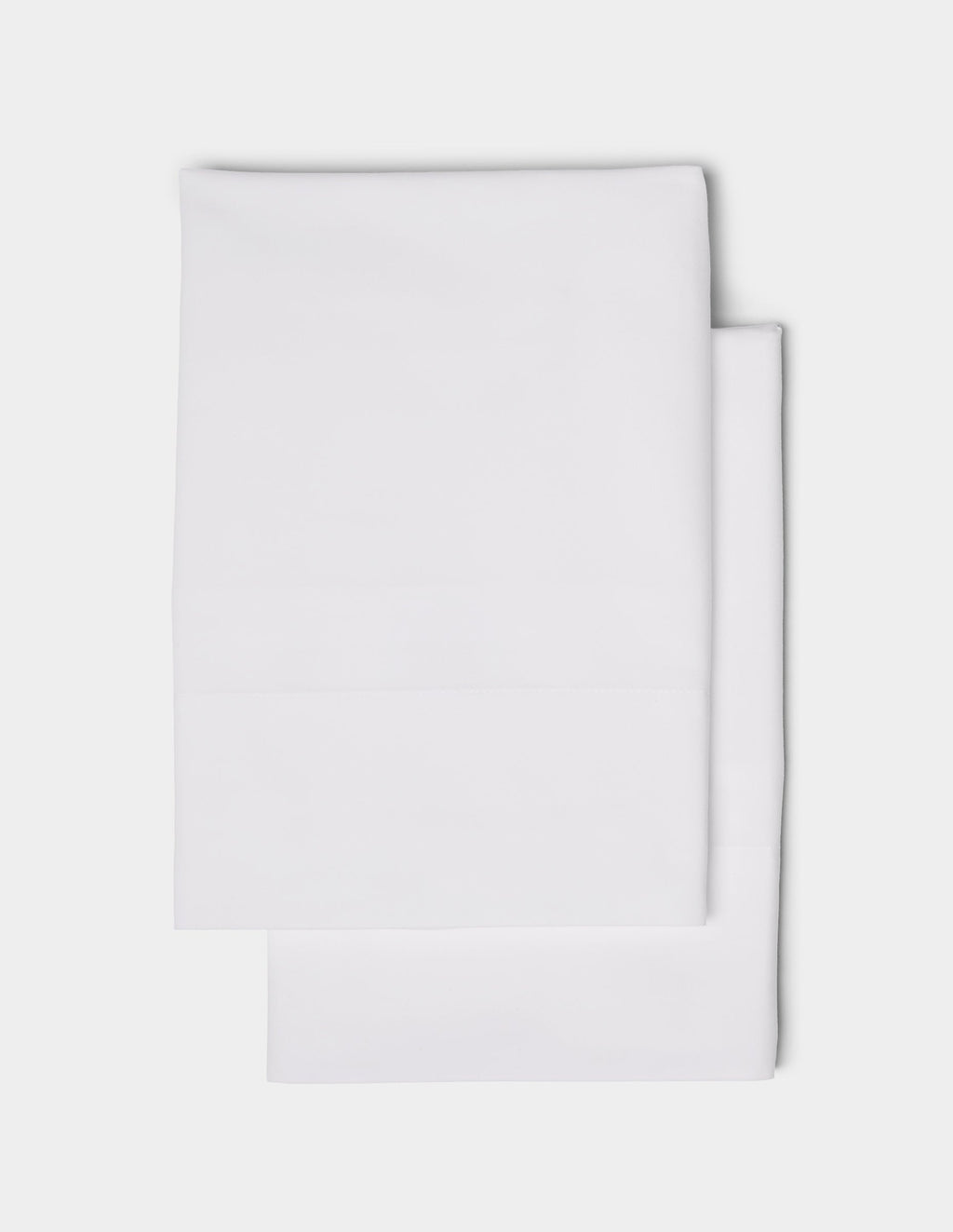 Two neatly folded Cozy Earth Soft-Wash Cotton Pillowcases are stacked on top of each other against a plain white background.|Color:White