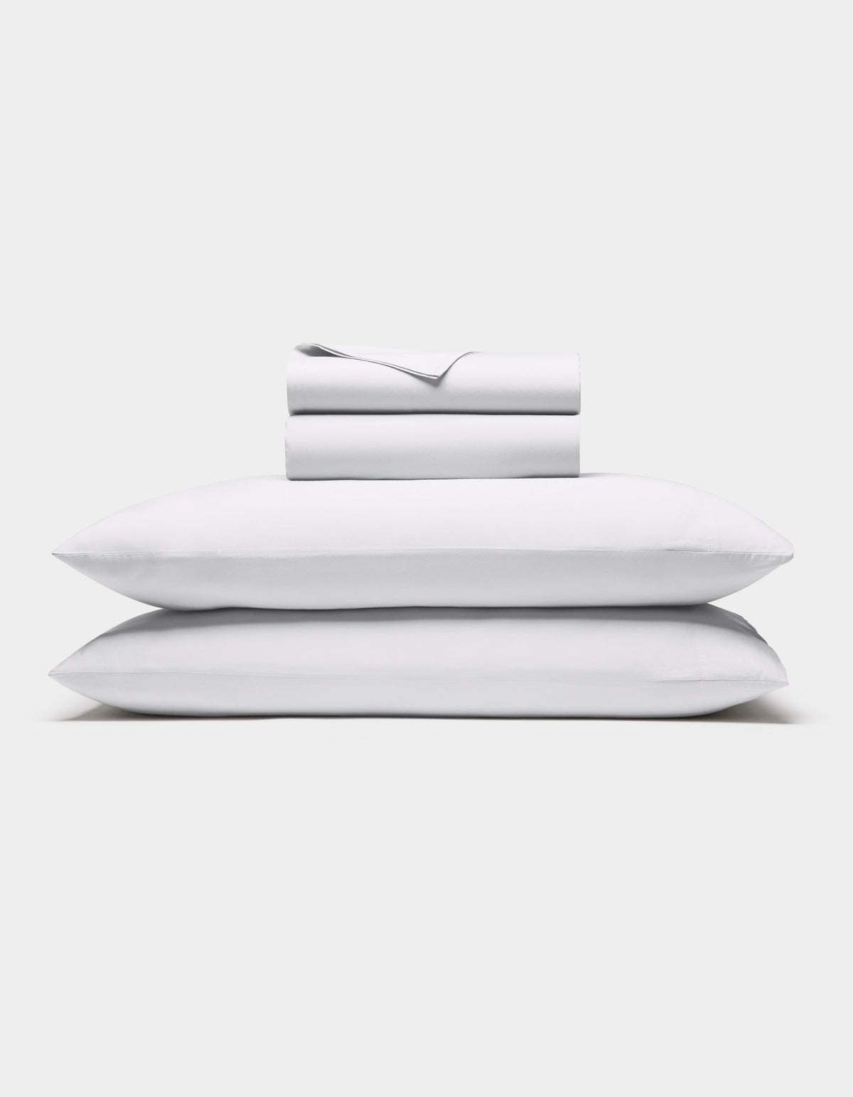 The Cozy Earth Soft-Wash Cotton Sheet Set in white, featuring a flat sheet, fitted sheet, and two pillowcases, is shown neatly stacked against a plain white background.|Color:White