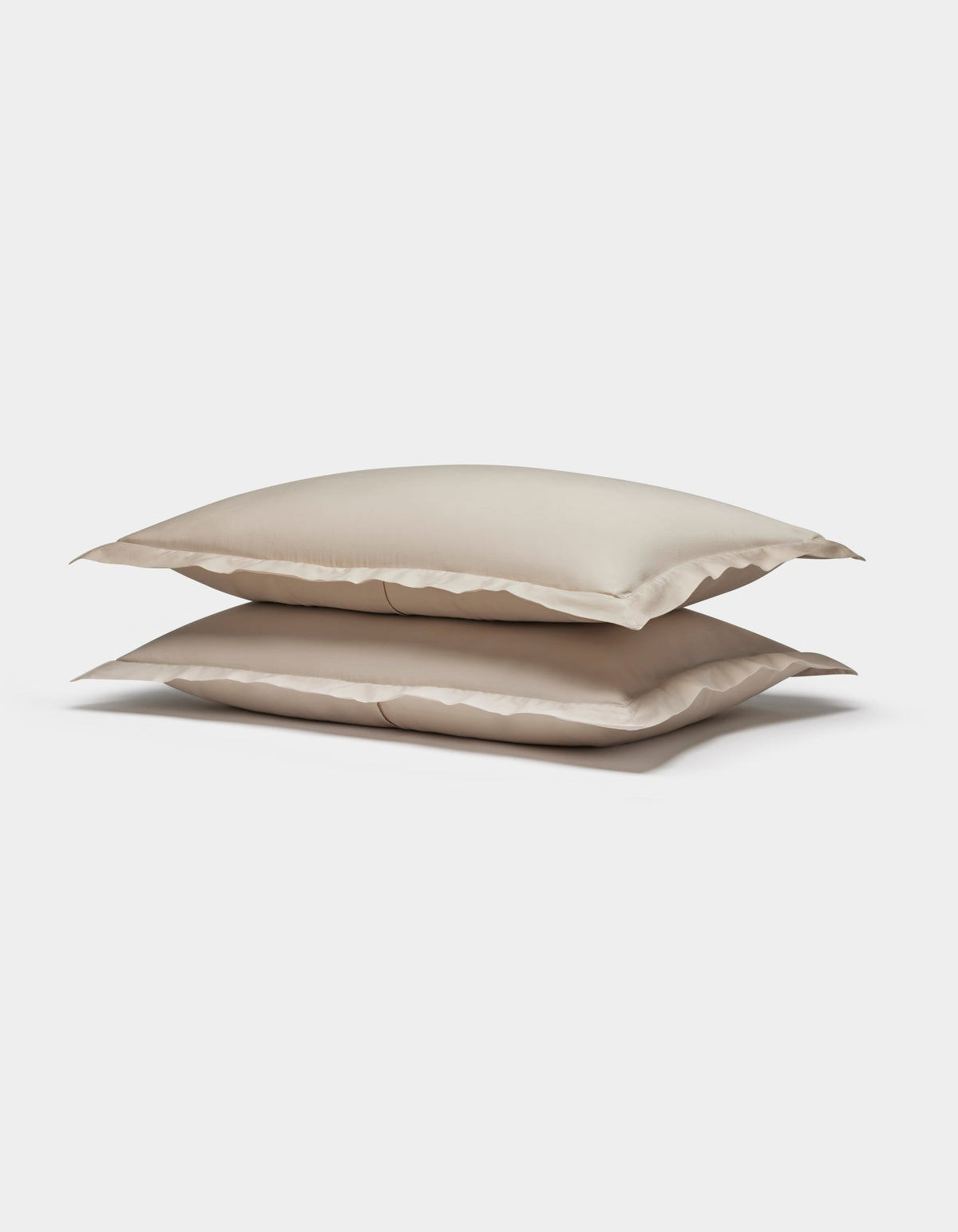 Two Soft-Wash Cotton Shams by Cozy Earth, in beige, are stacked neatly together against a plain white background.|Color:Driftwood