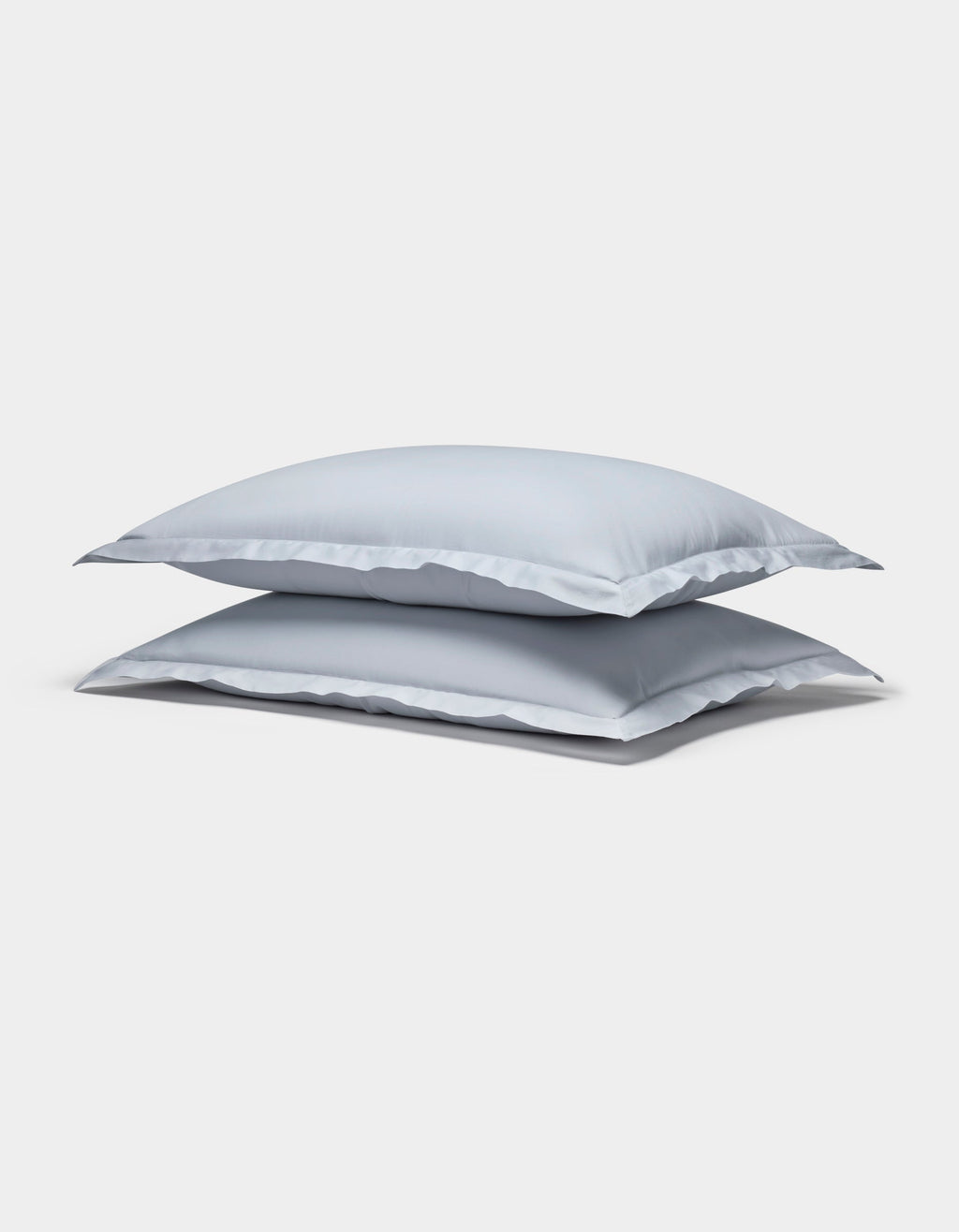 Two Cozy Earth Soft-Wash Cotton Shams in light gray are stacked neatly against a plain white background.|Color:Shore