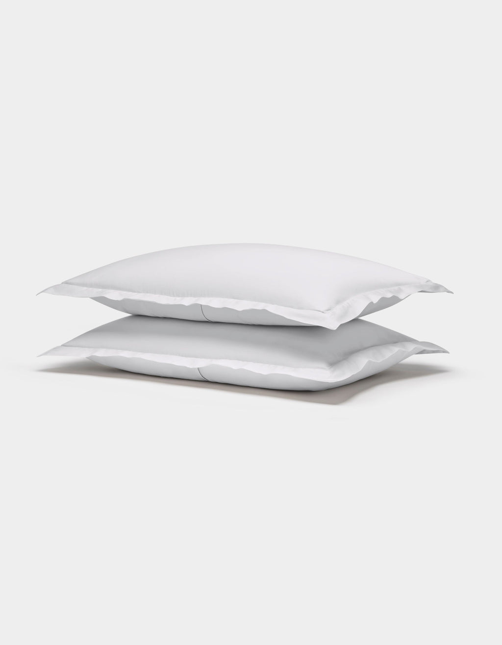 Two Cozy Earth Soft-Wash Cotton Shams are stacked neatly on top of each other against a plain white background.|Color:White