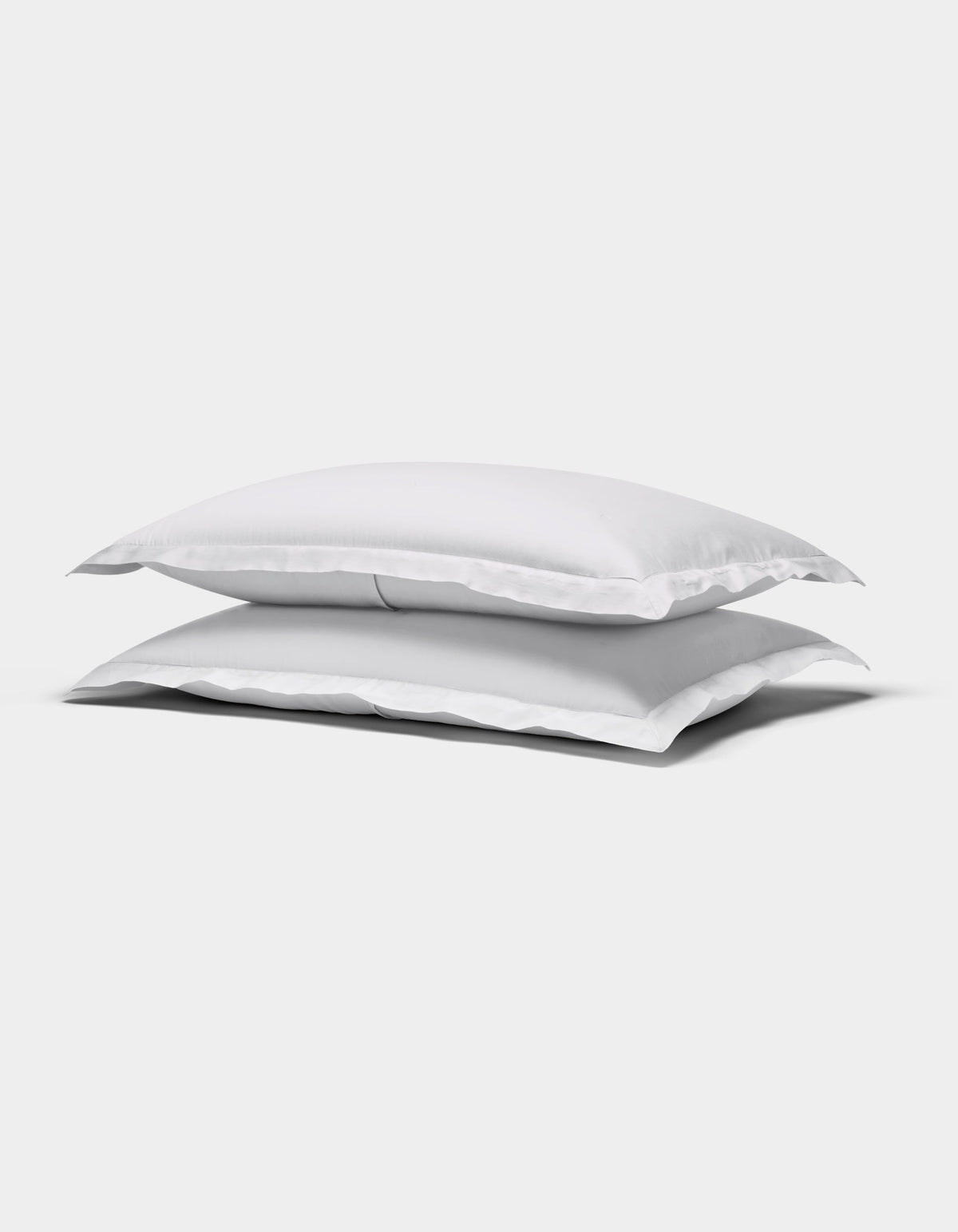 Two Cozy Earth Soft-Wash Cotton Quilted Shams, rectangular and white, are stacked atop each other against a plain white background.|Color:White