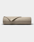 A Cozy Earth Bamboo Jersey Flat Sheet in beige is neatly folded and displayed on a plain, light gray background.|Color:Driftwood