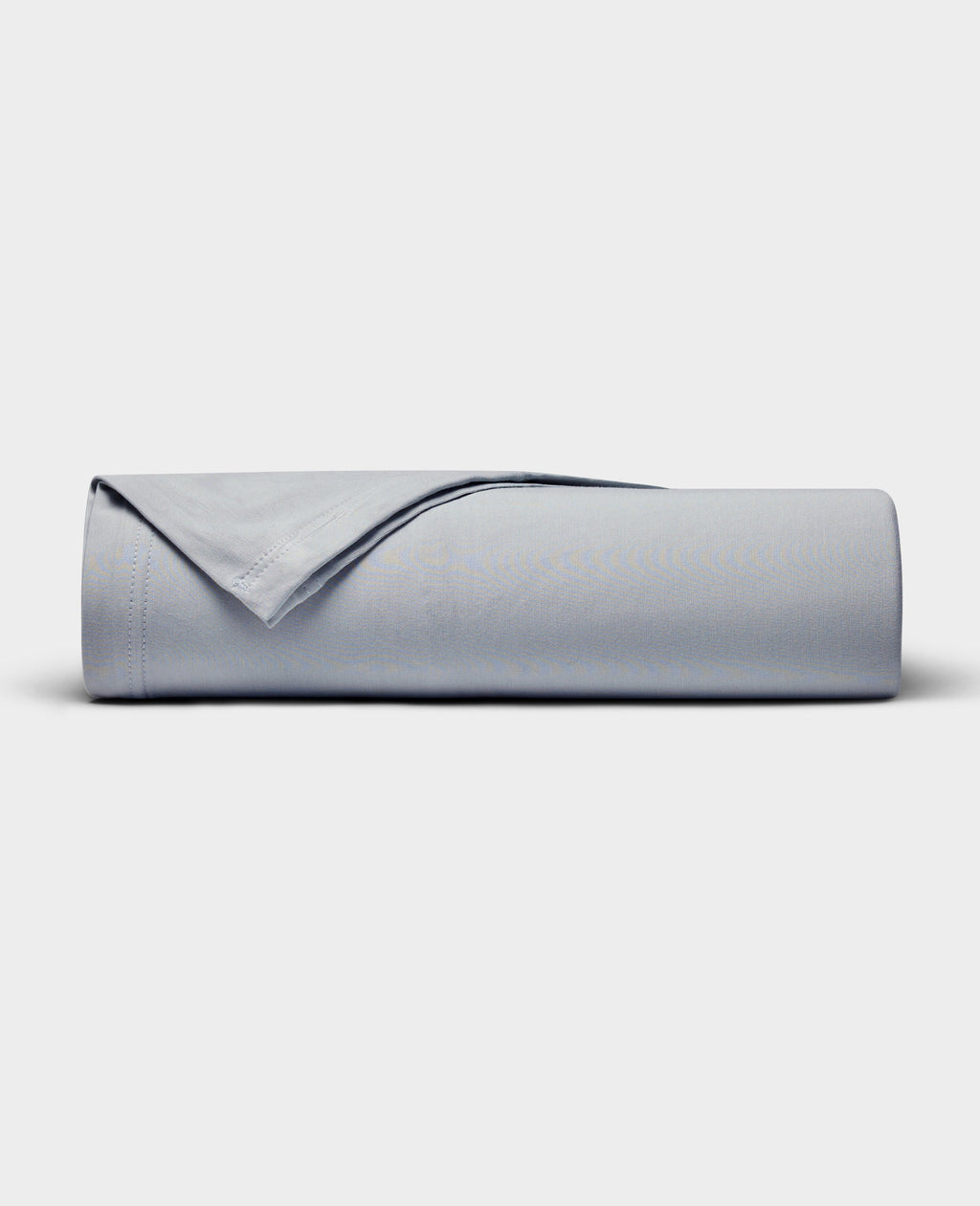 The Cozy Earth Bamboo Jersey Flat Sheet is neatly rolled with a folded edge and displayed on a plain white background.|Color:Shore