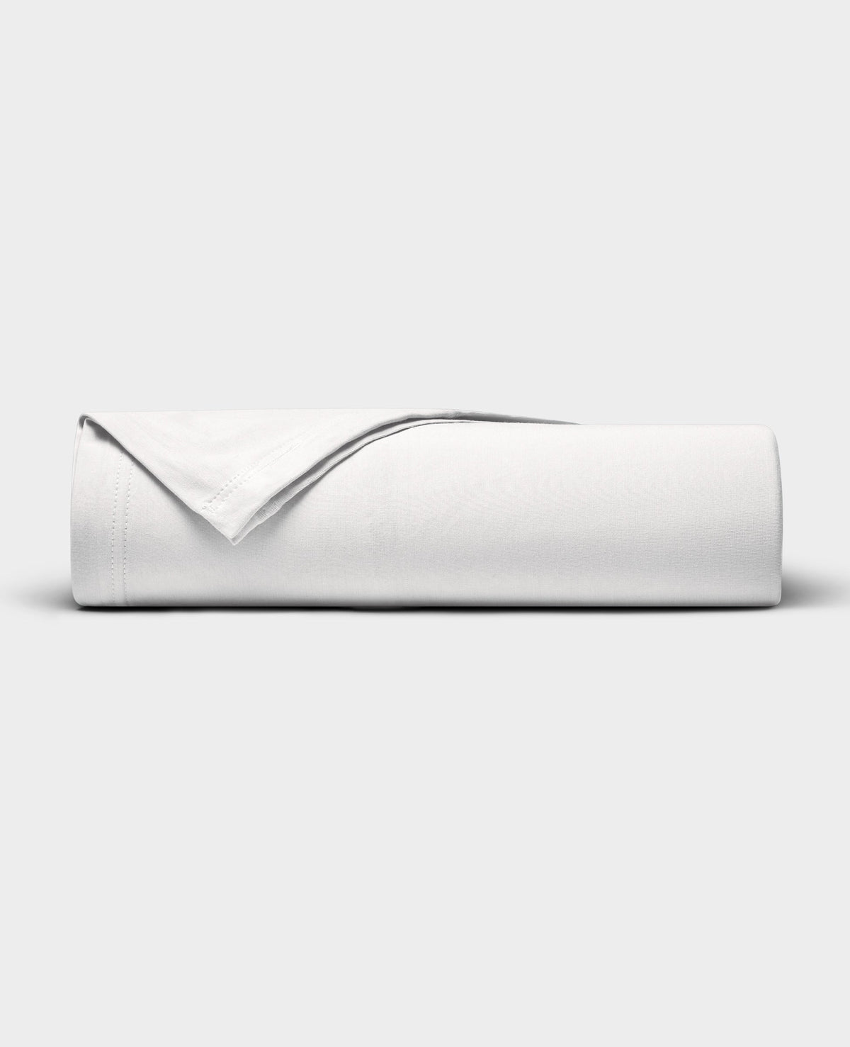 The Cozy Earth Bamboo Jersey Flat Sheet is neatly folded with a corner turned back, showcased against a plain light gray background.|Color:White