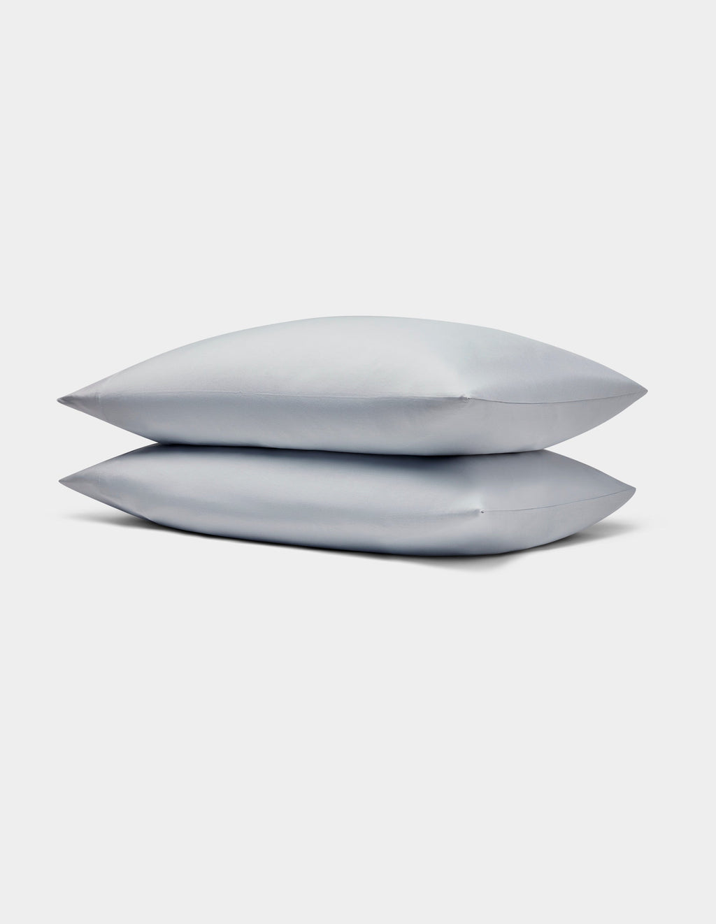 Two light gray Bamboo Jersey Pillowcases by Cozy Earth stacked neatly on each other against a plain white background.|Color:Shore