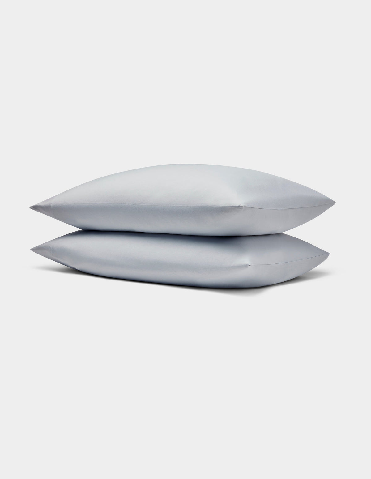Two light gray Bamboo Jersey Pillowcases by Cozy Earth stacked neatly on each other against a plain white background.|Color:Shore