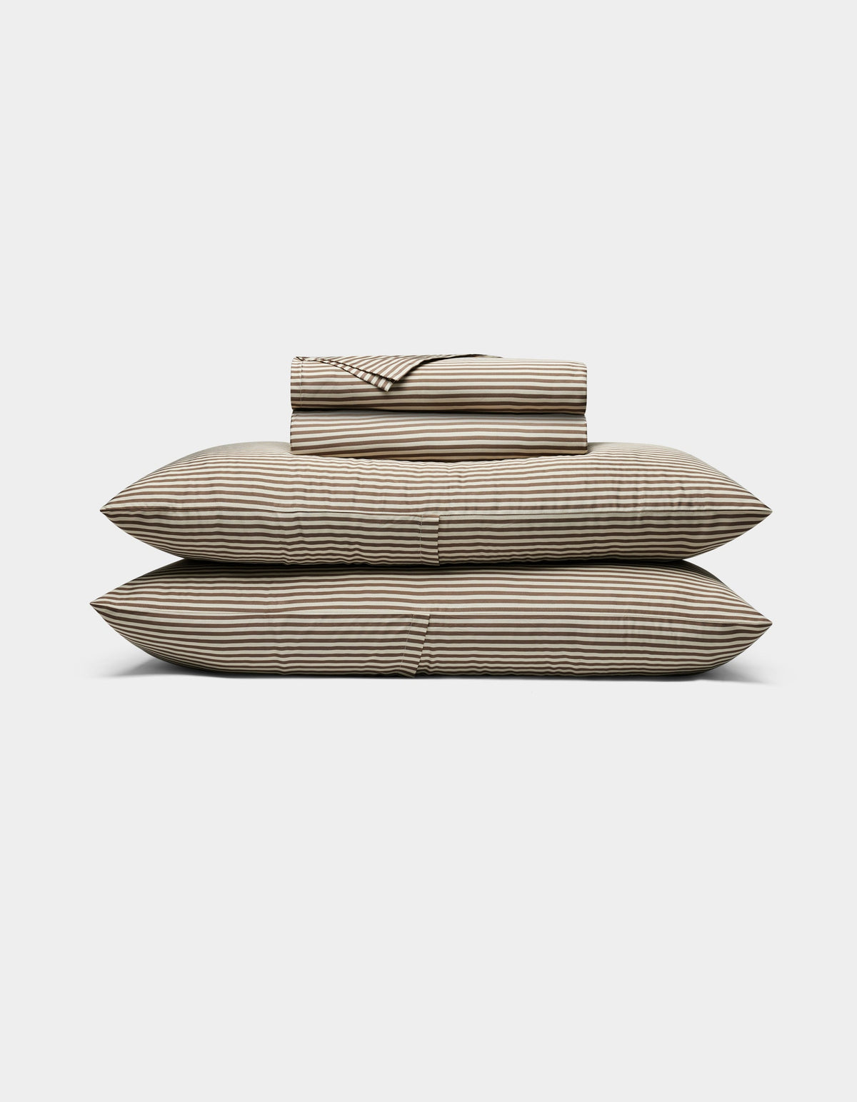 The Cozy Earth Bamboo Sheet Set, featuring striped beige and black sheets and pillowcases, is neatly stacked on two large pillows against a plain white background.|Color:Classic Stripe in Ebony
