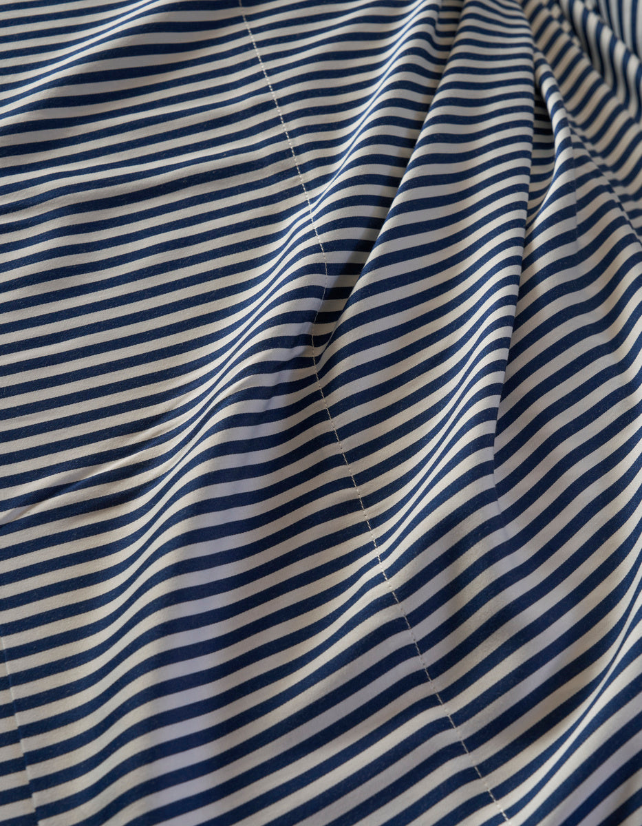 A close-up of the Cozy Earth Bamboo Duvet Cover shows thin, evenly spaced navy blue and white horizontal stripes with visible stitching and gentle folds.|Color:Classic Stripe in Pacific