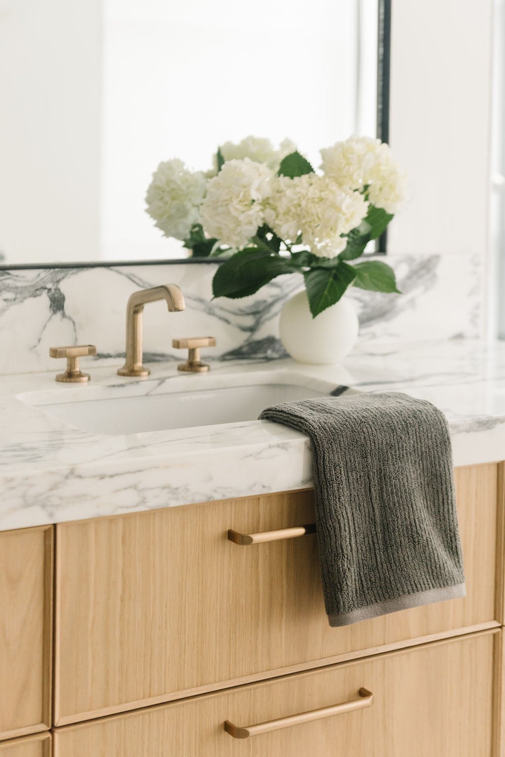 Ribbed Terry Hand Towel in the color Charcoal. Photo of Ribbed Terry Hand Towel taken with the Ribbed Terry Hand Towel resting on a bathroom sink. |Color: Charcoal