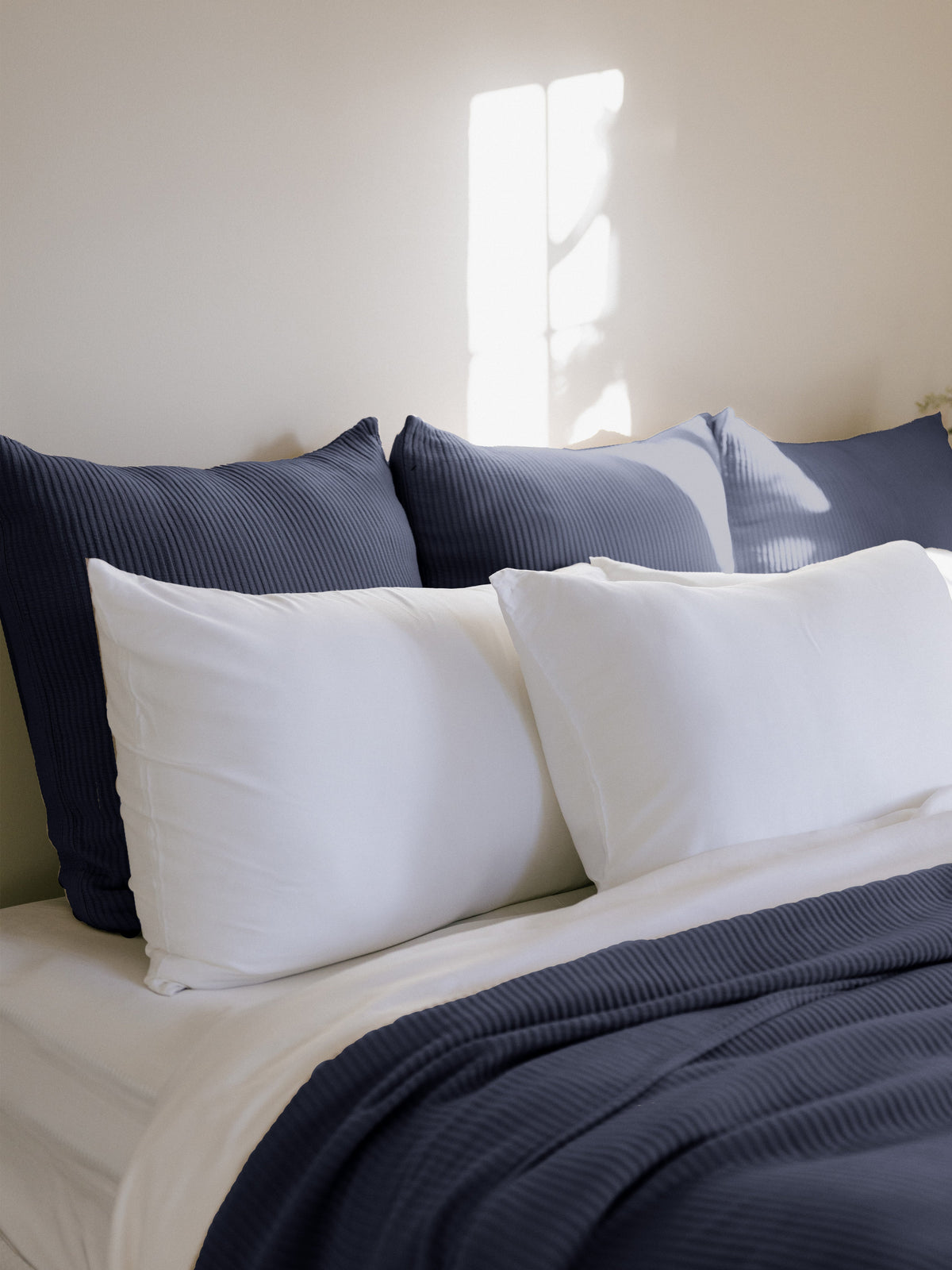 Navy euro coverlet shams behind white pillows on bed |Color:Navy