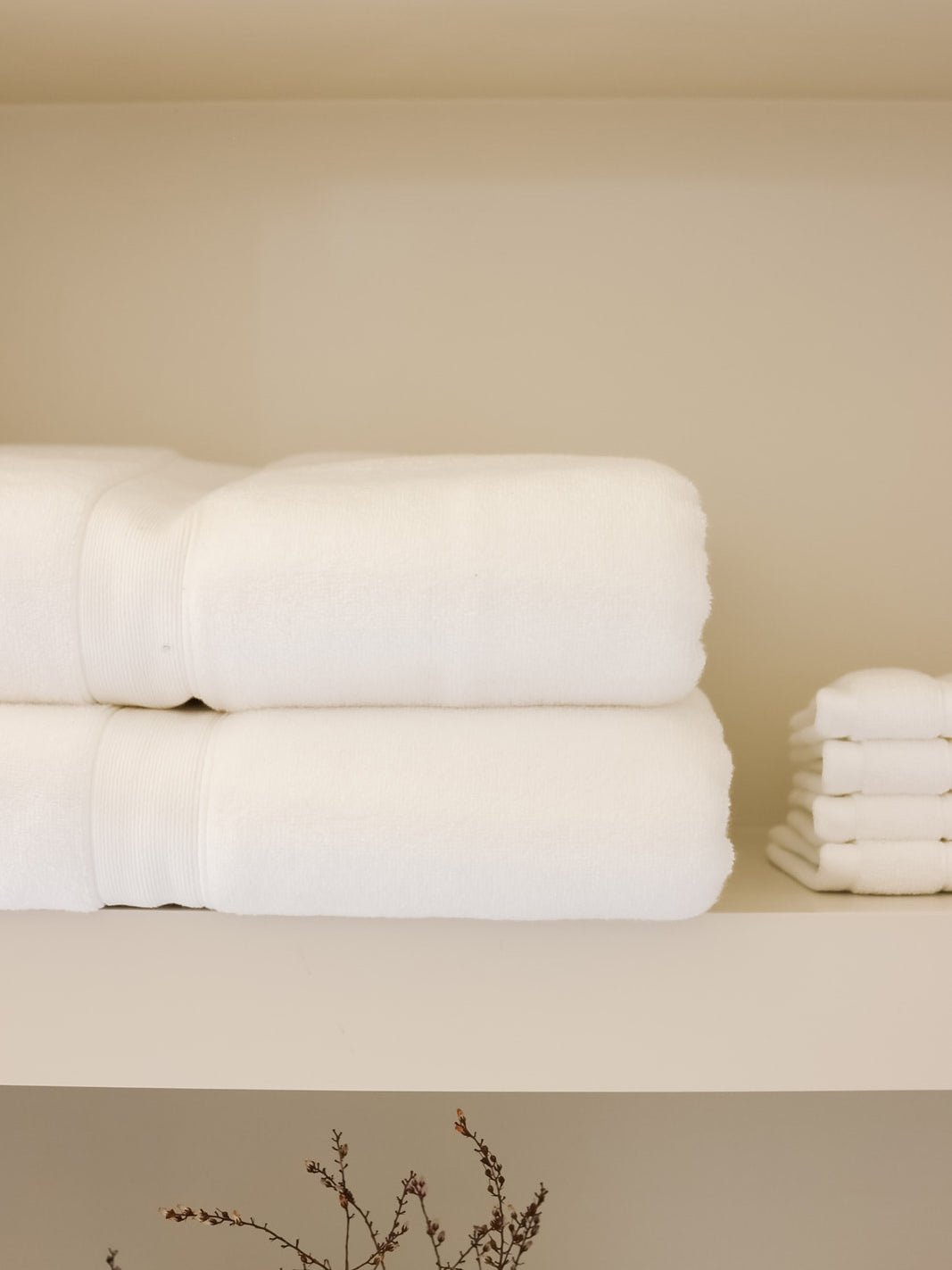 White luxe bath towels and washcloths folded on shelf |Color:White