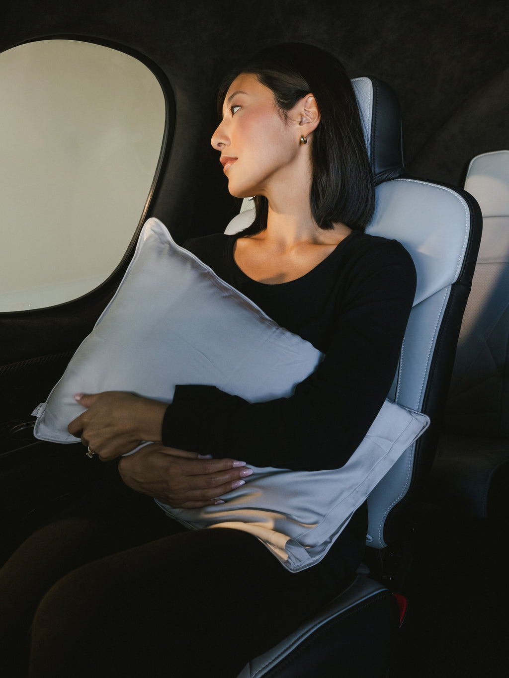 Woman holding travel pillow in airplane |Size:Travel