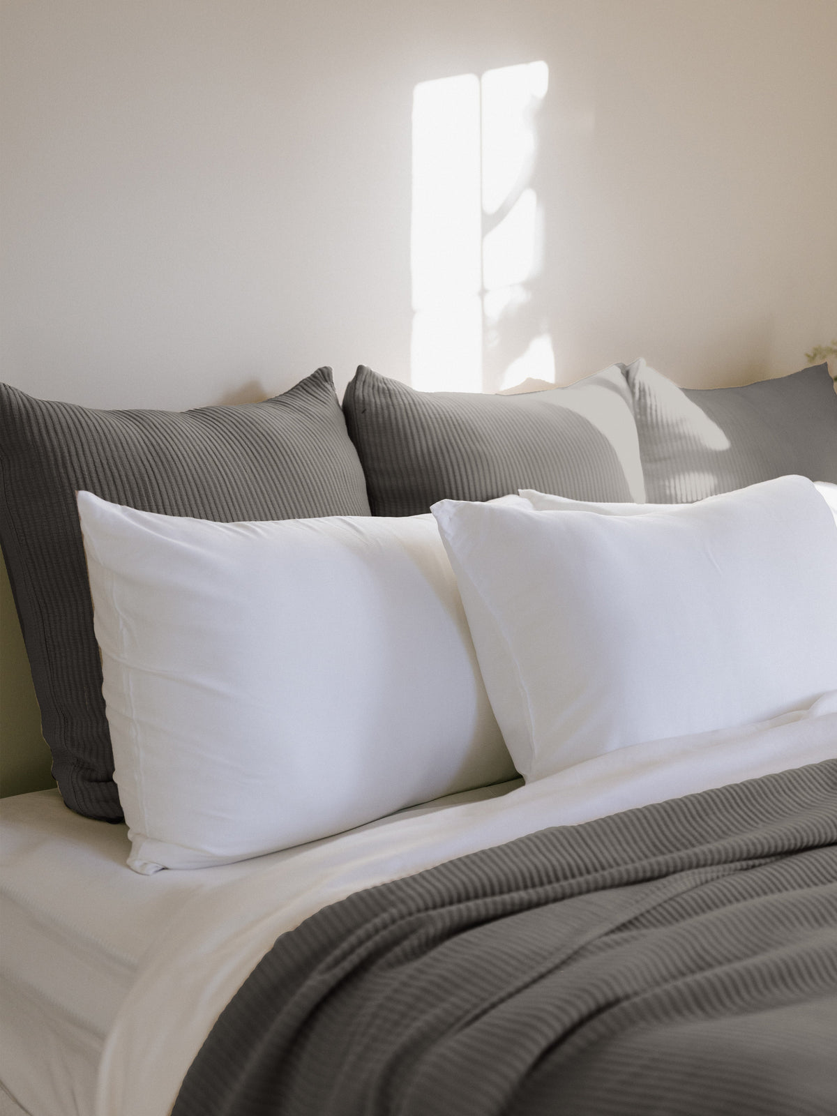 Charcoal euro coverlet shams behind white pillows on a bed |Color:Charcoal