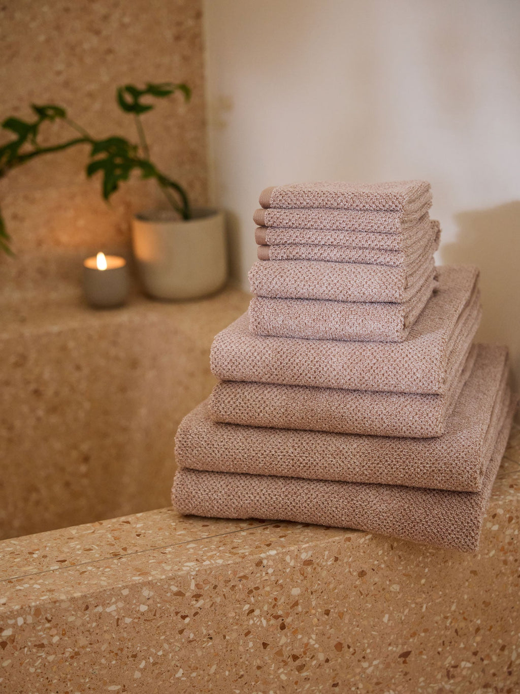 The Complete Nantucket Bath Bundle is pictured sitting on the edge of a stone bathtub. |Color:Heathered Clay