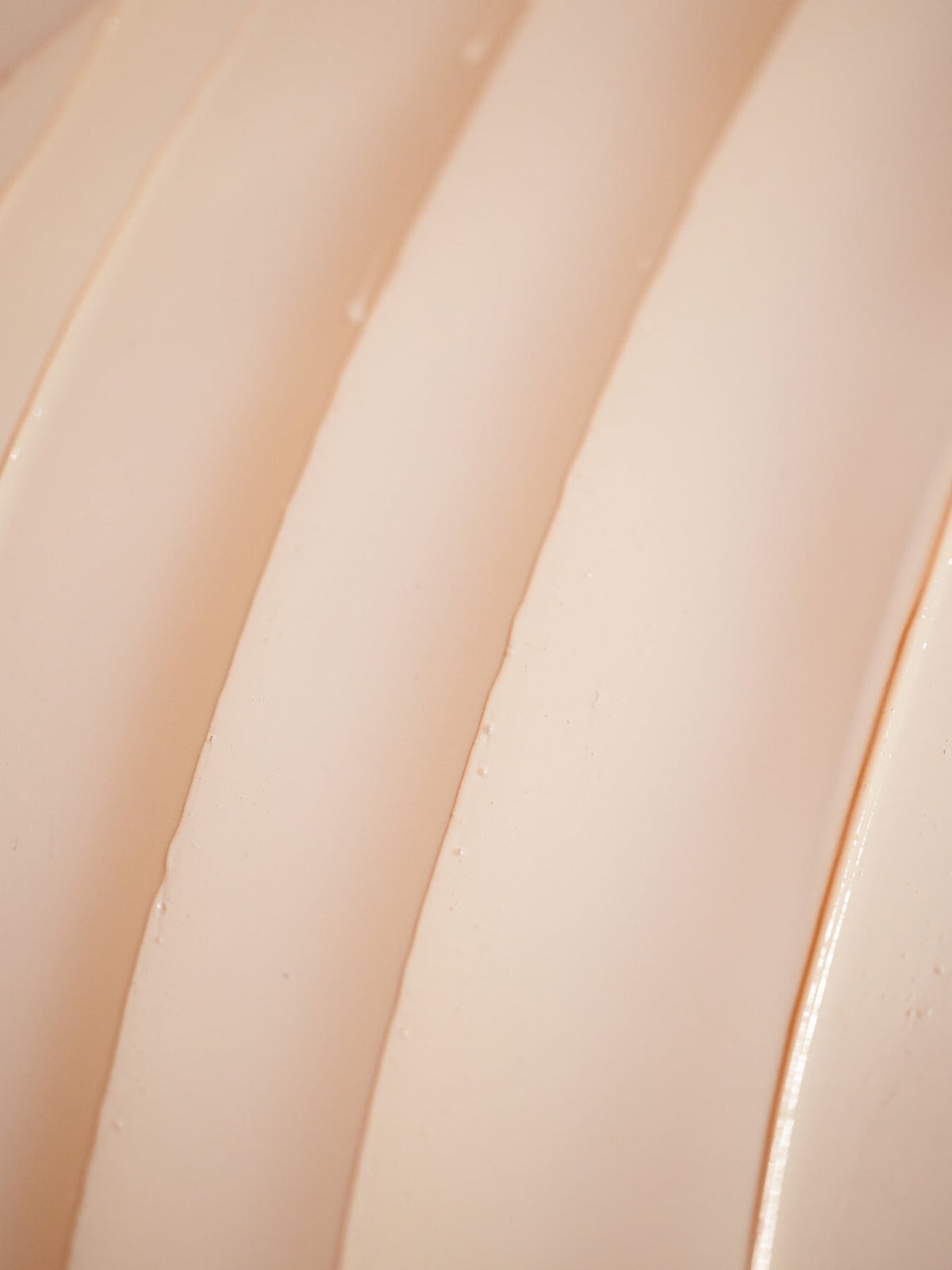 A close-up of the smooth, cream-colored surface of Cozy Earth's Clay Mask. Gentle lighting highlights its texture, showing parallel lines and a glossy appearance. |Size:Mini