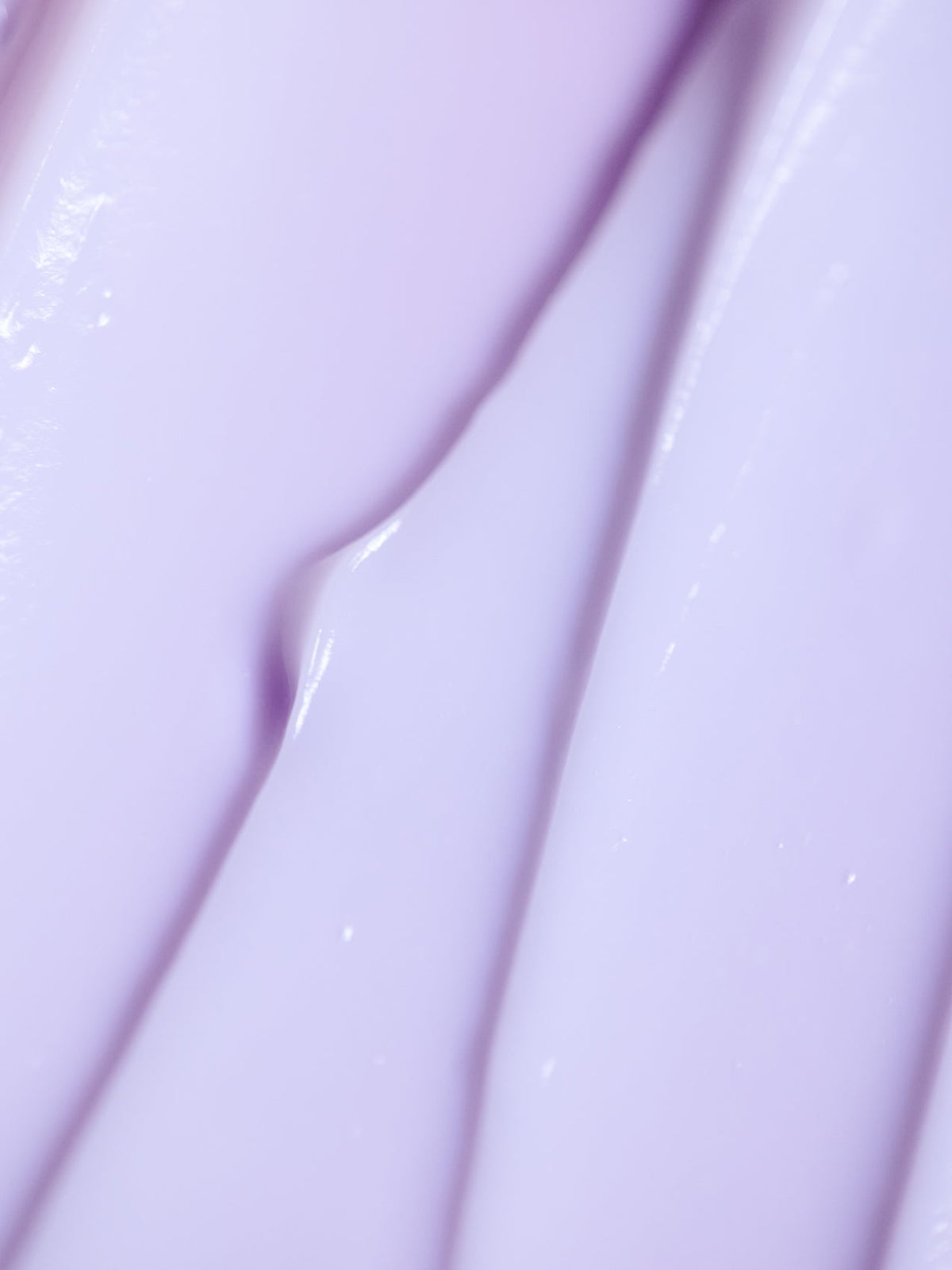 Close-up of Cozy Earth's Night Cream, showcasing its smooth purple texture with light reflections forming an abstract pattern of creamy ridges and folds. |Size:Full Size