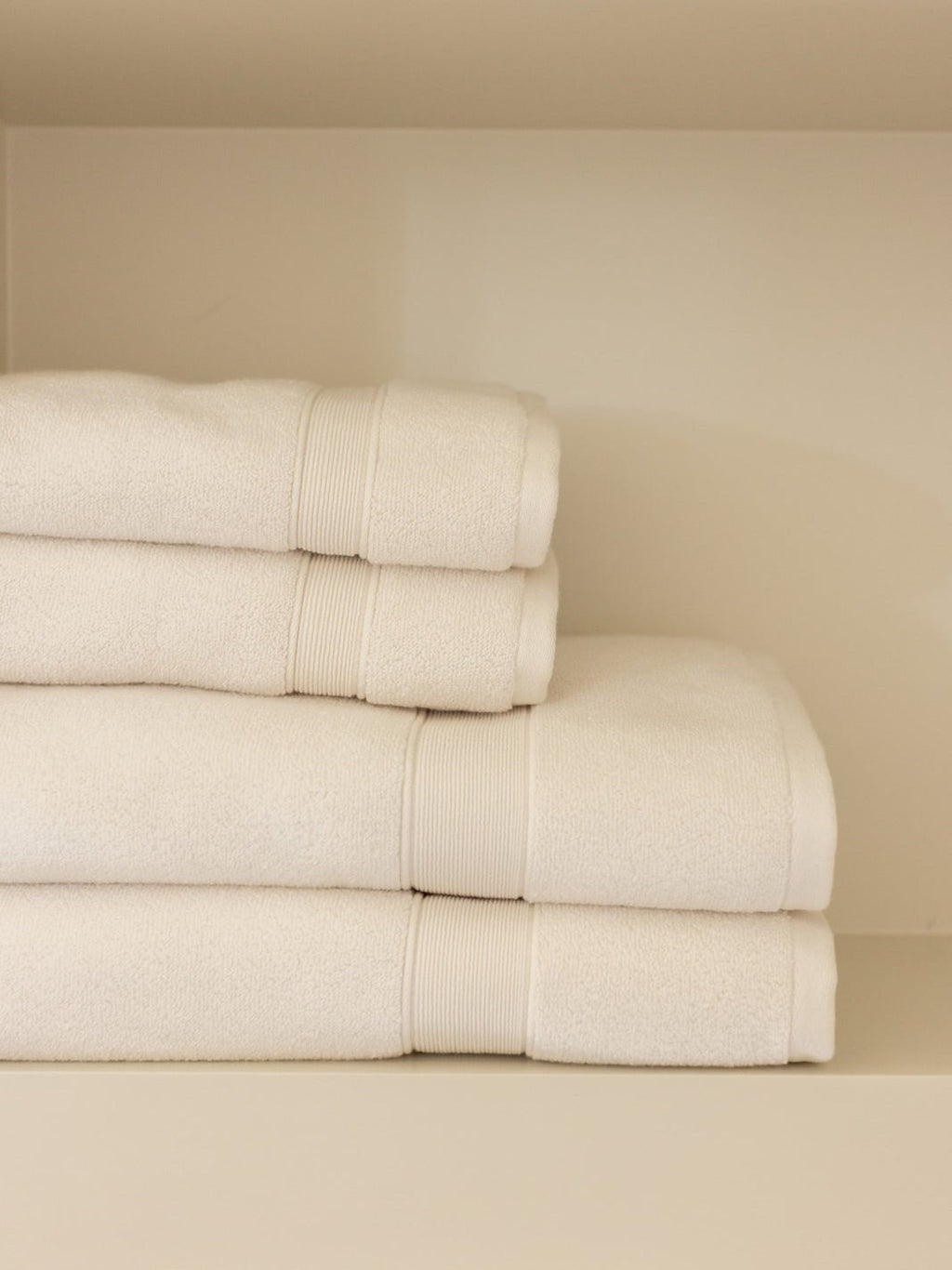 Seashell luxe bath towels and hand towels folded on shelf |Color:Seashell