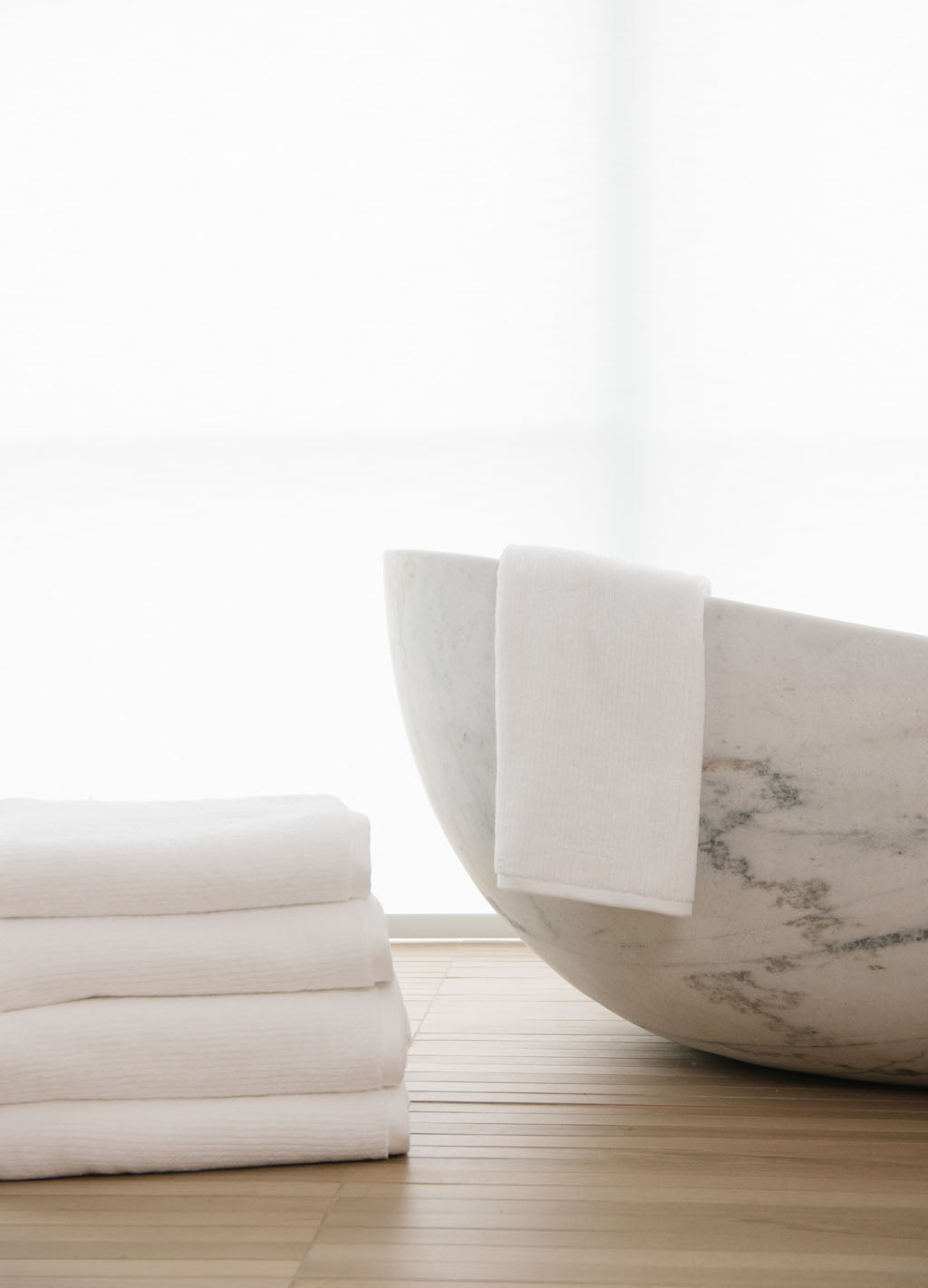White Ribbed Terry Hand Towels in the color white next to a white marble bath tub.|ColorWhite