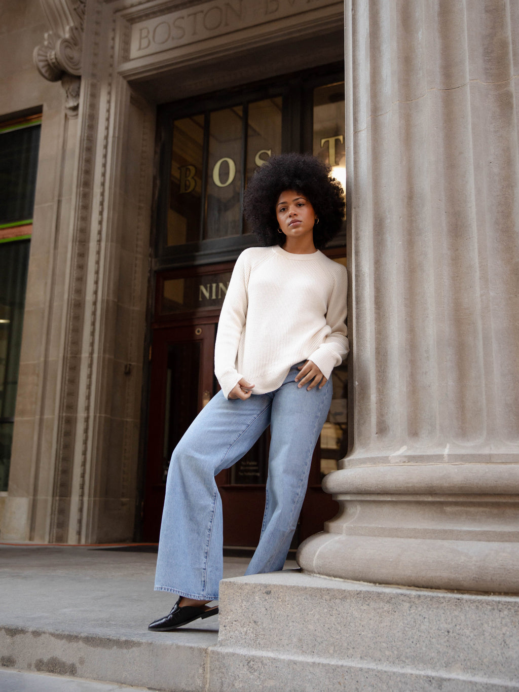Woman wearing alabaster classic crewneck and jeans outside of building |Color:Alabaster