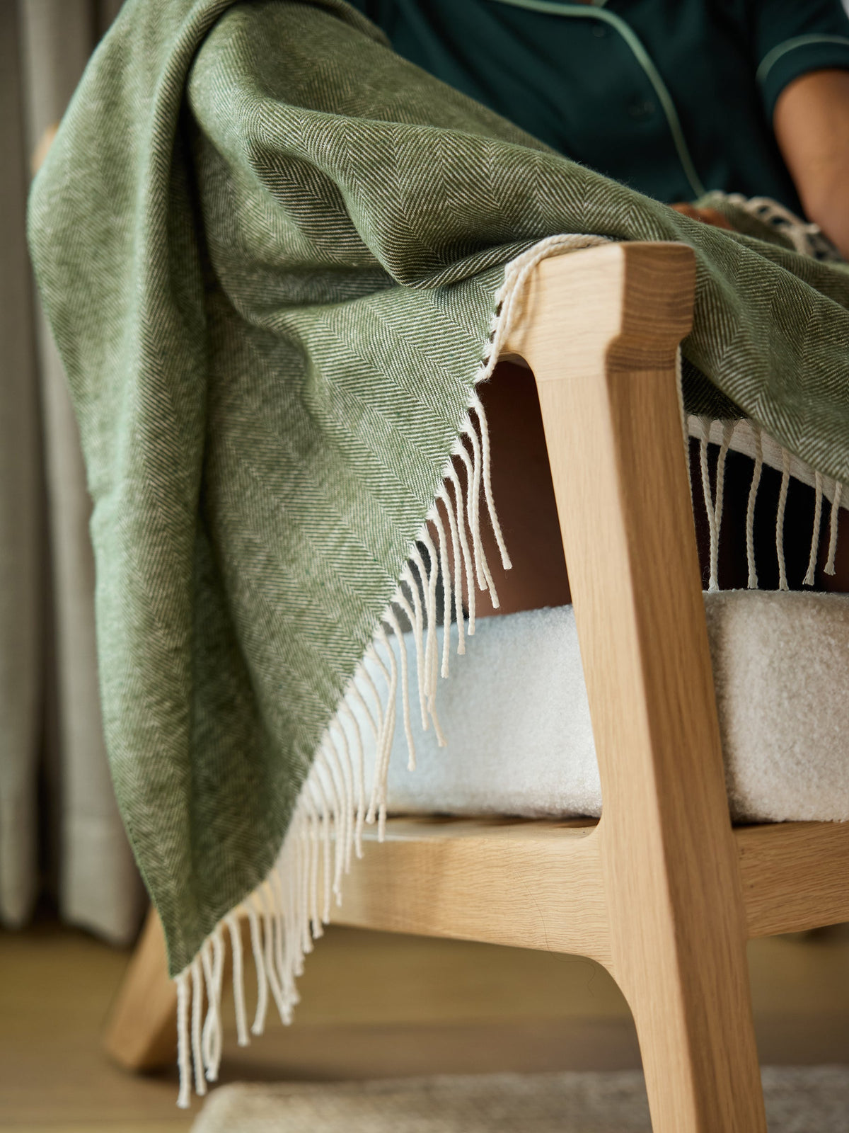 Close up of ivy herringbone tassel throw draped over chair |Color:Ivy