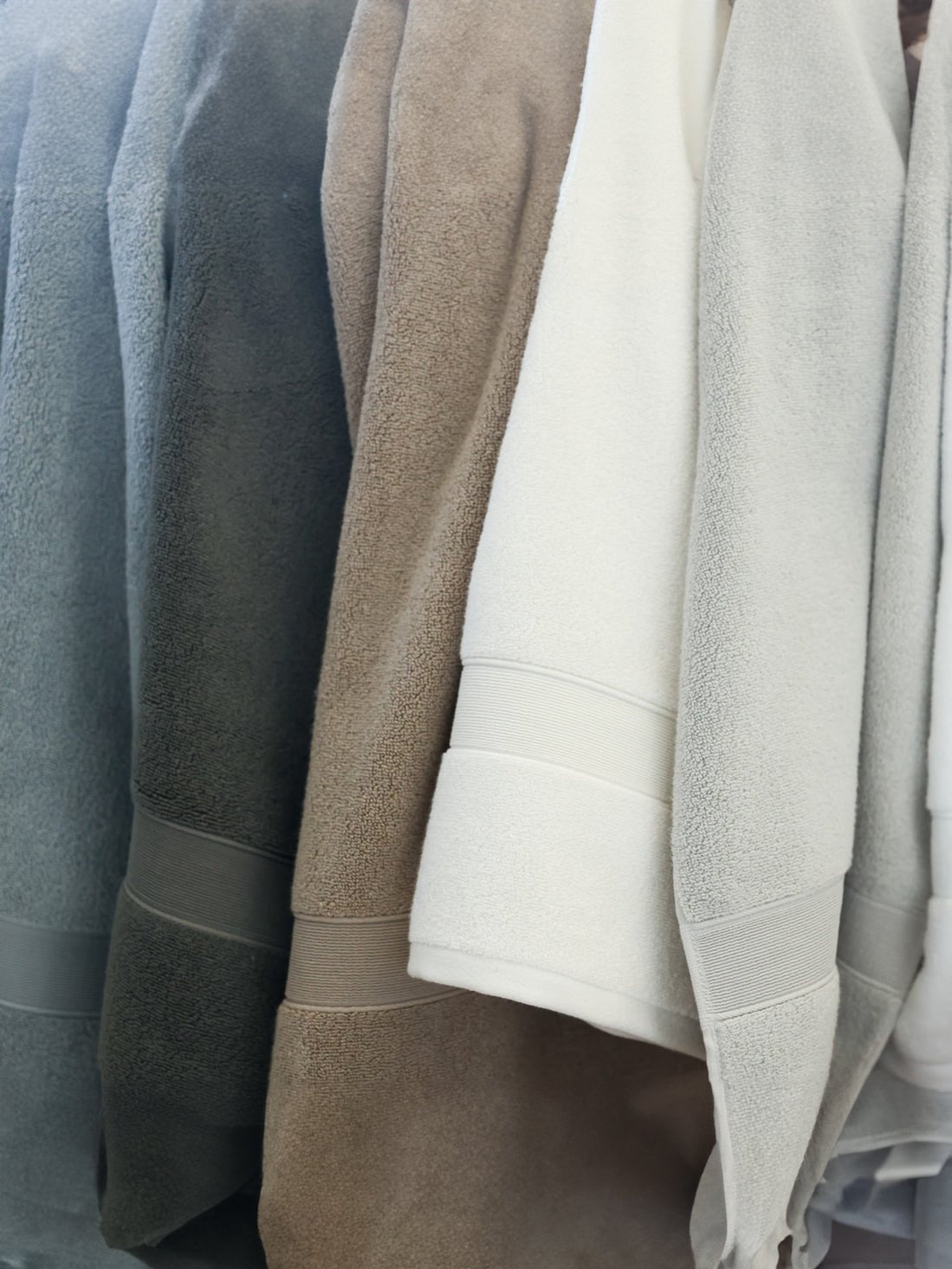 White, sand, light grey, harbor mist, charcoal, and seashell luxe bath towels hanging side by side |Color:White