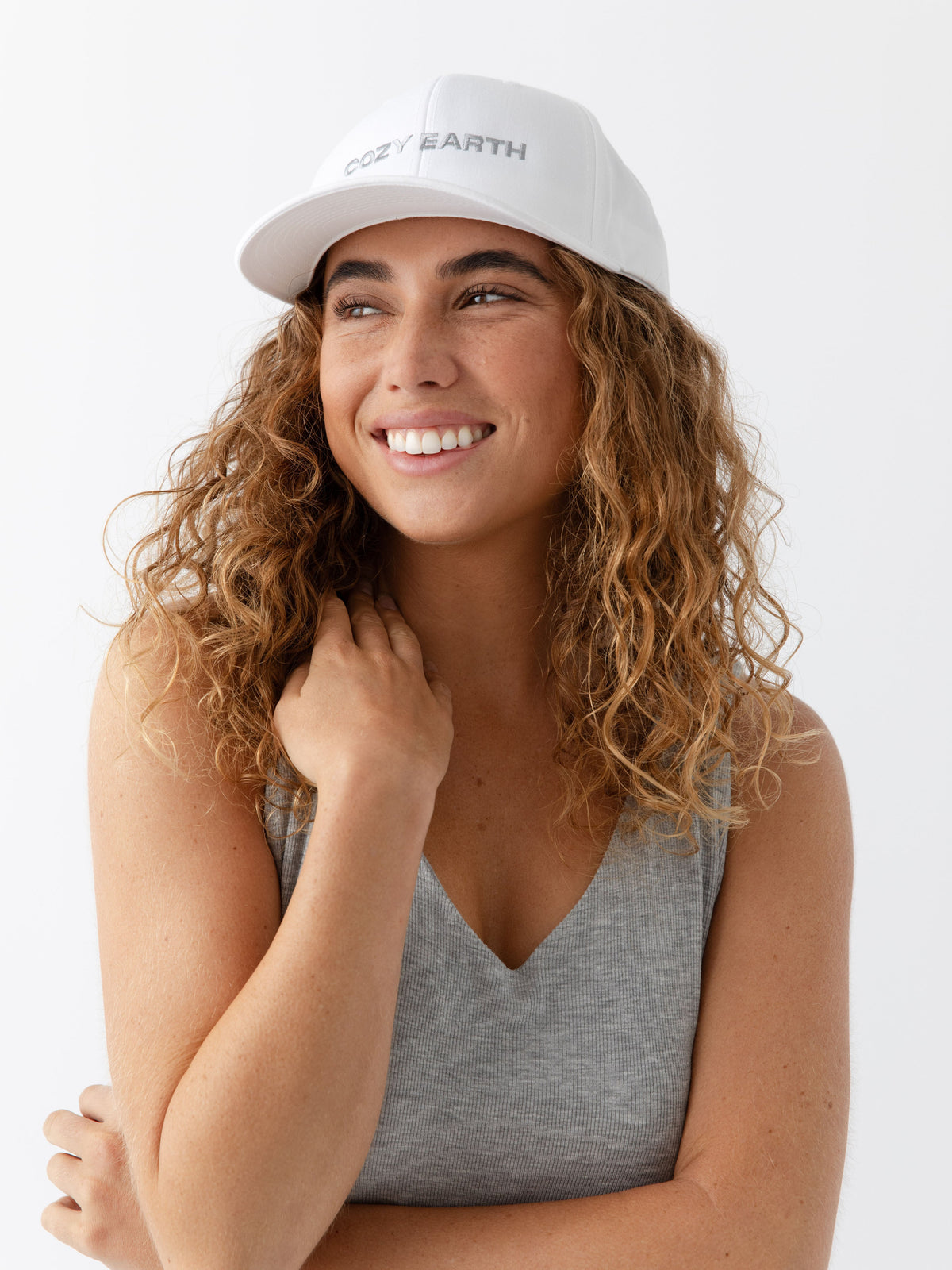 A woman wearing a White cap with 'COZY EARTH' text on a white background |Color:White/Stone