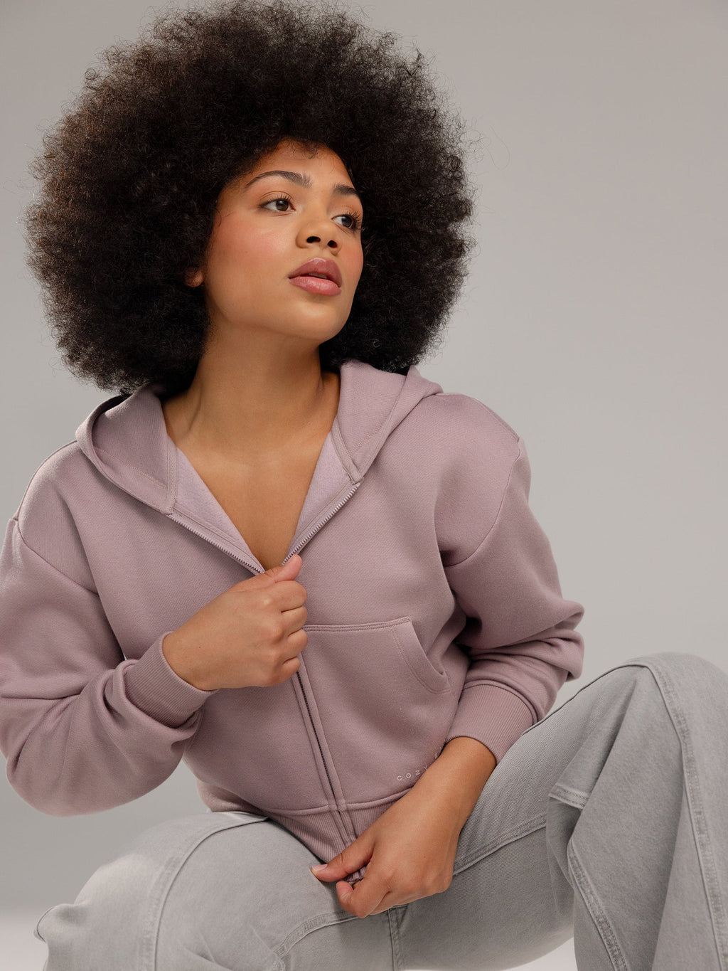 Woman wearing Dusty Orchid CityScape Cropped Full Zip with grey background |Color: Dusty Orchid