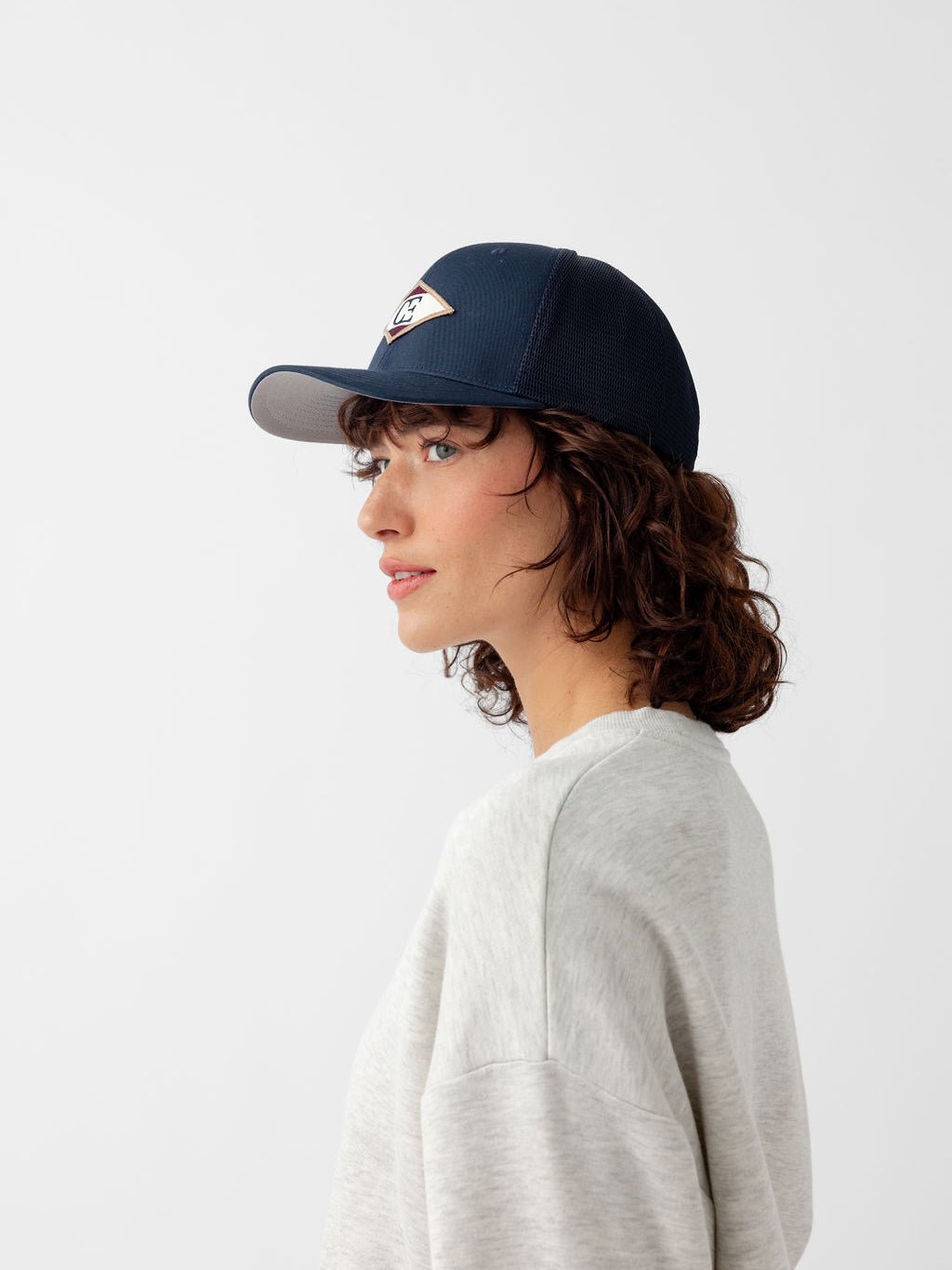 Side view of woman wearing navy diamond mesh trucker hat |Color:Navy