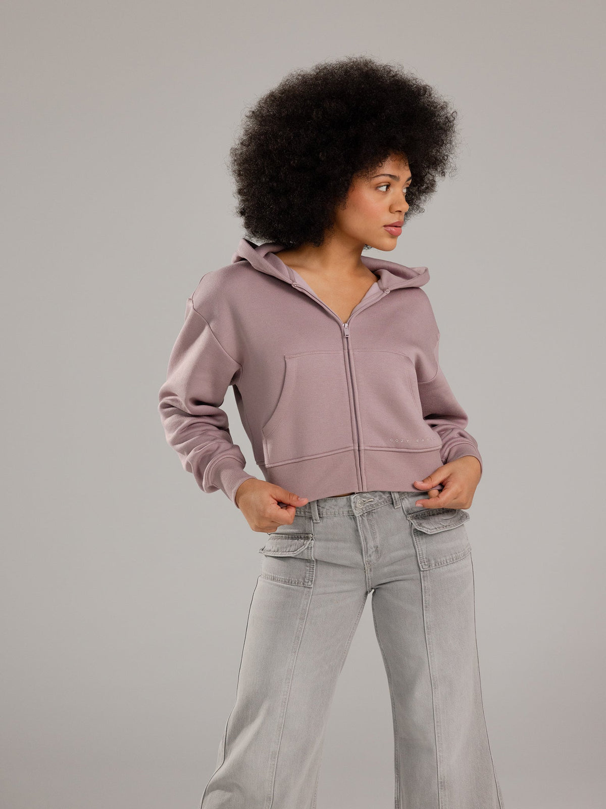 Woman wearing Dusty Orchid CityScape Cropped Full Zip with grey background |Color: Dusty Orchid