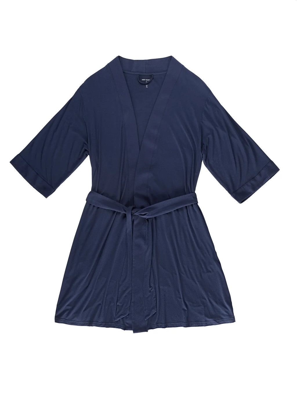 A navy blue Women's Stretch-Knit Bamboo Kimono Robe by Cozy Earth is displayed flat against a white background, showcasing its smooth, elegant fabric. The robe features three-quarter sleeves and comes with a matching belt. |Color:Navy