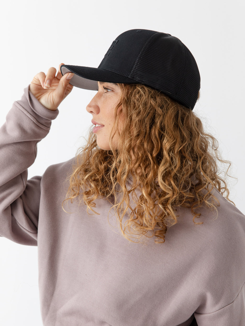 Woman wearing a black cap with a CE logo on a light gray background |Color:Black