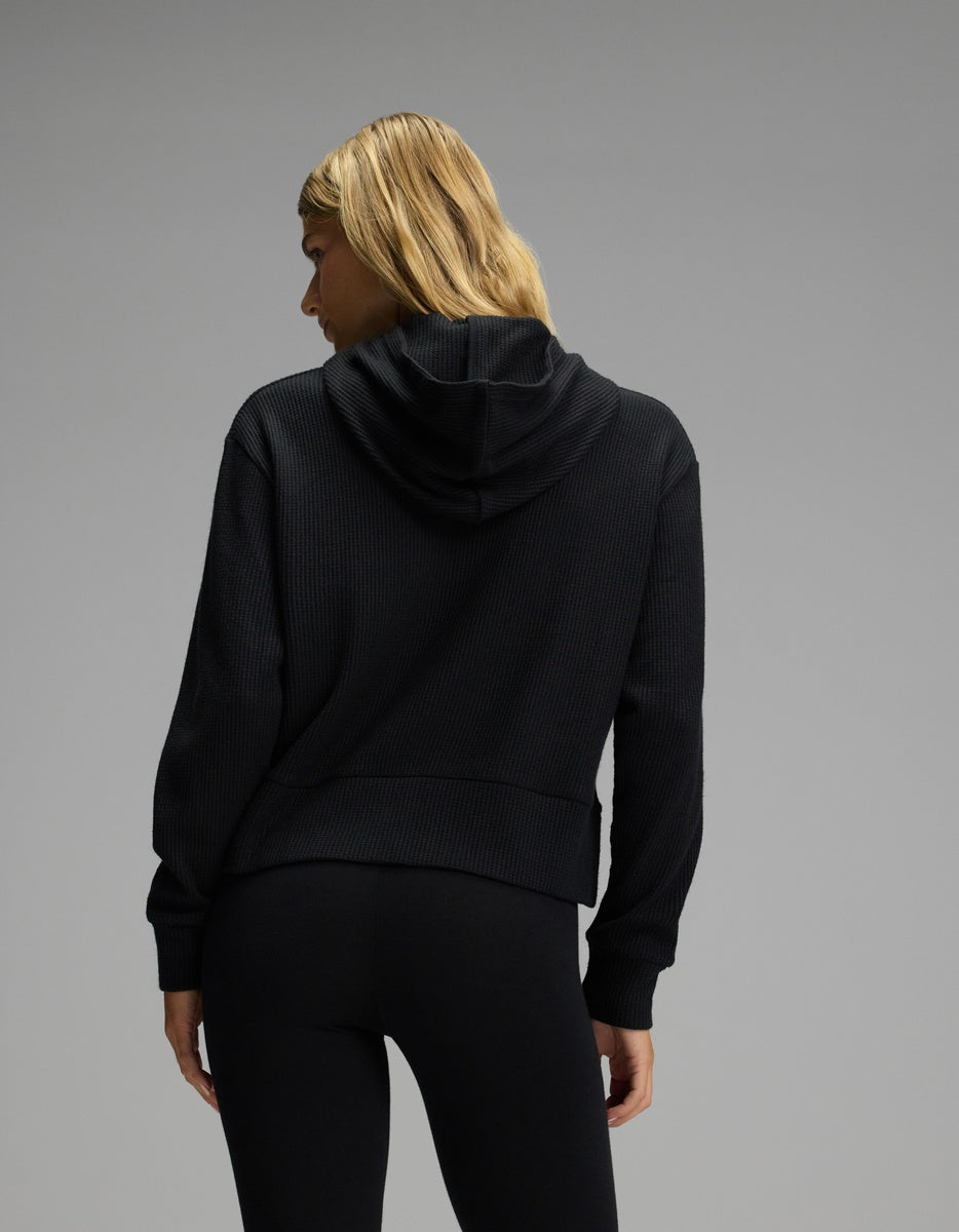 Back view of a person wearing a black long-sleeve Women’s Blake Waffle Hoodie.|Color:Jet Black