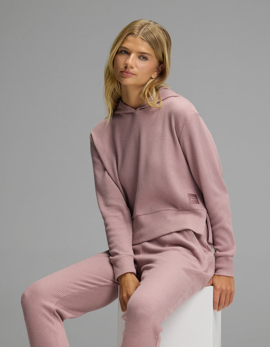 A person wearing a dusty pink Women’s Blake Waffle Hoodie & Jogger Set featuring a waffle-knit hoodie and matching jogger pants.|Color:Viola