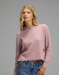A woman wears a mauve, long-sleeved Cozy Earth Women’s Blake Waffle Hoodie.|Color:Viola