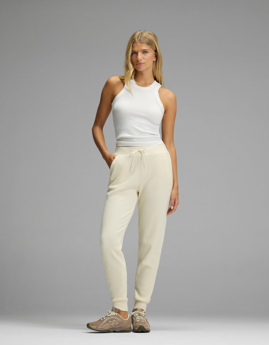 Woman wearing a white ribbed tank top and cream-colored Women’s Blake Waffle Jogger with a drawstring waist.|Color:Coconut