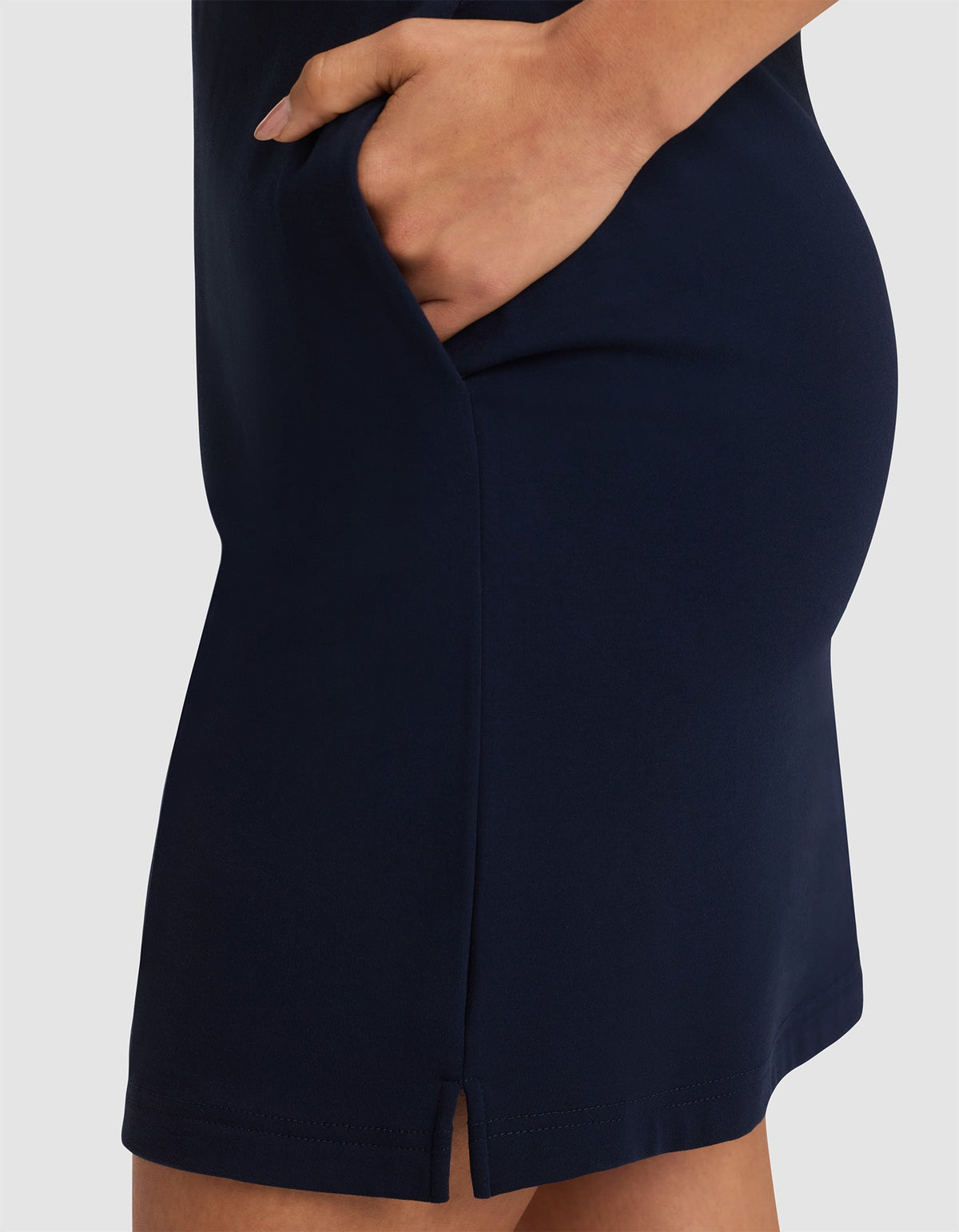 A close-up shows a person wearing the Cozy Earth Women's Brushed Bamboo Skirt in navy blue with a small front slit, their hand resting inside the skirt pocket. |Color:Navy