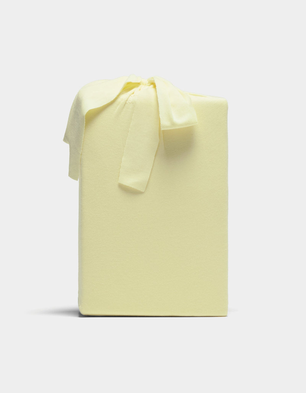 A Cozy Earth Bamboo Jersey Sheet Set, neatly wrapped in pale yellow fabric with a matching bow, is displayed against a plain light background.|Color:Meringue