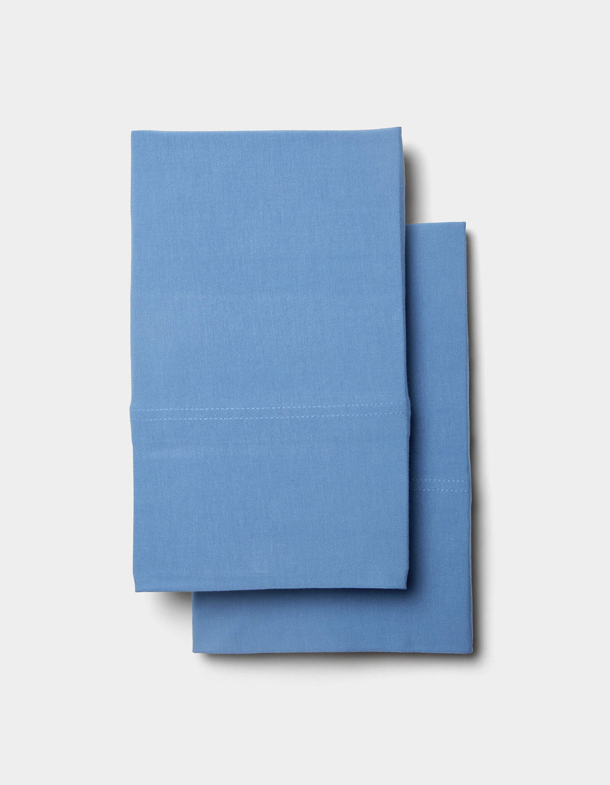 A pair of neatly folded Cozy Earth Bamboo Jersey Sheet Set linens stacked on a plain white background.|Color:Sailor
