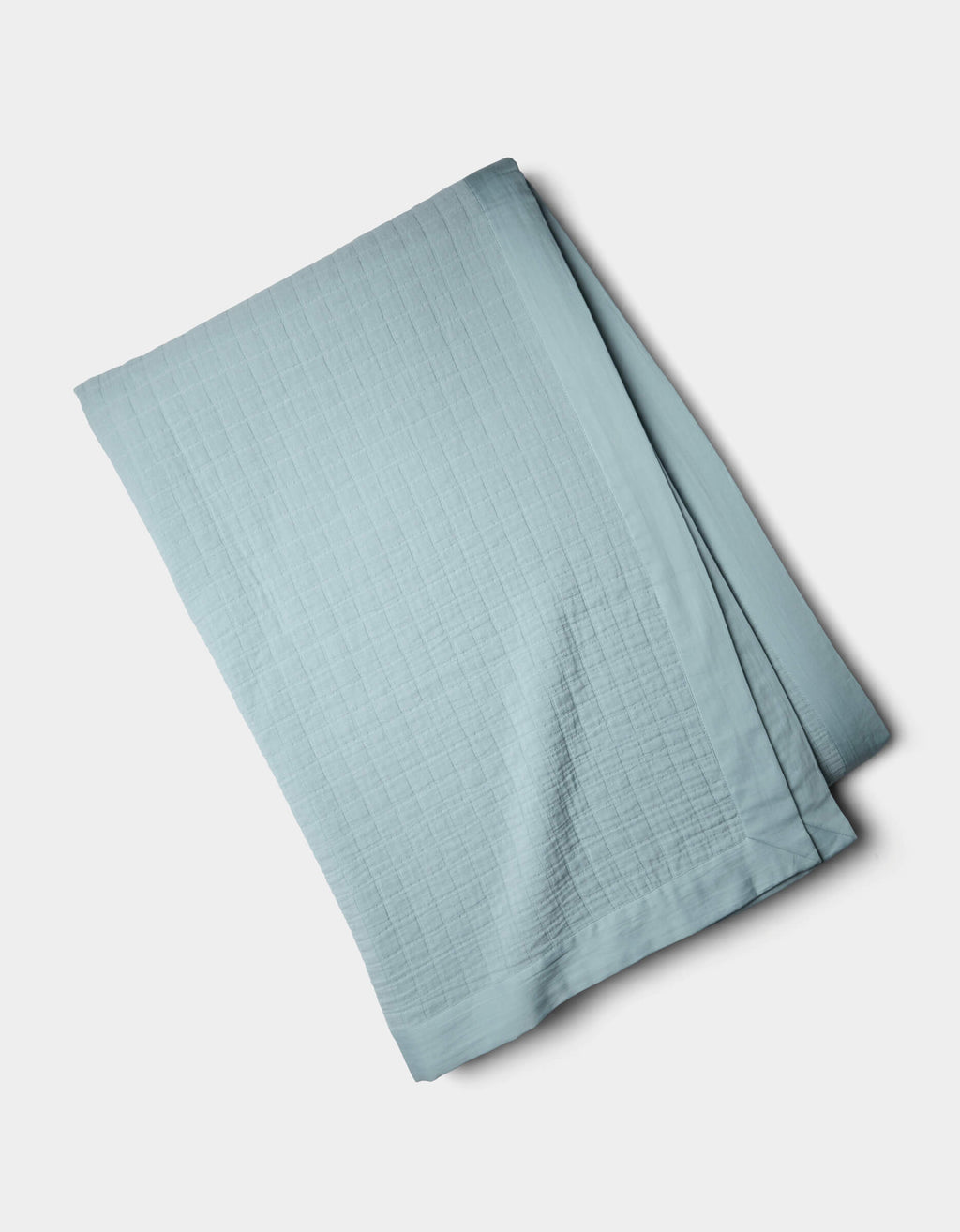 The Cozy Earth Waterfront Grid Matelasse Blanket, in light blue with a subtle grid pattern, is neatly folded and displayed on a plain white background.|Color:River
