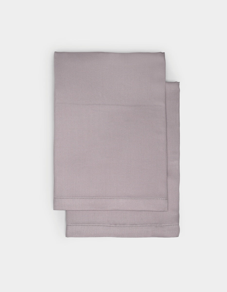 Two neatly folded light gray Cozy Earth Bamboo Pillowcases are stacked on a plain, light background.|Color:Lavender
