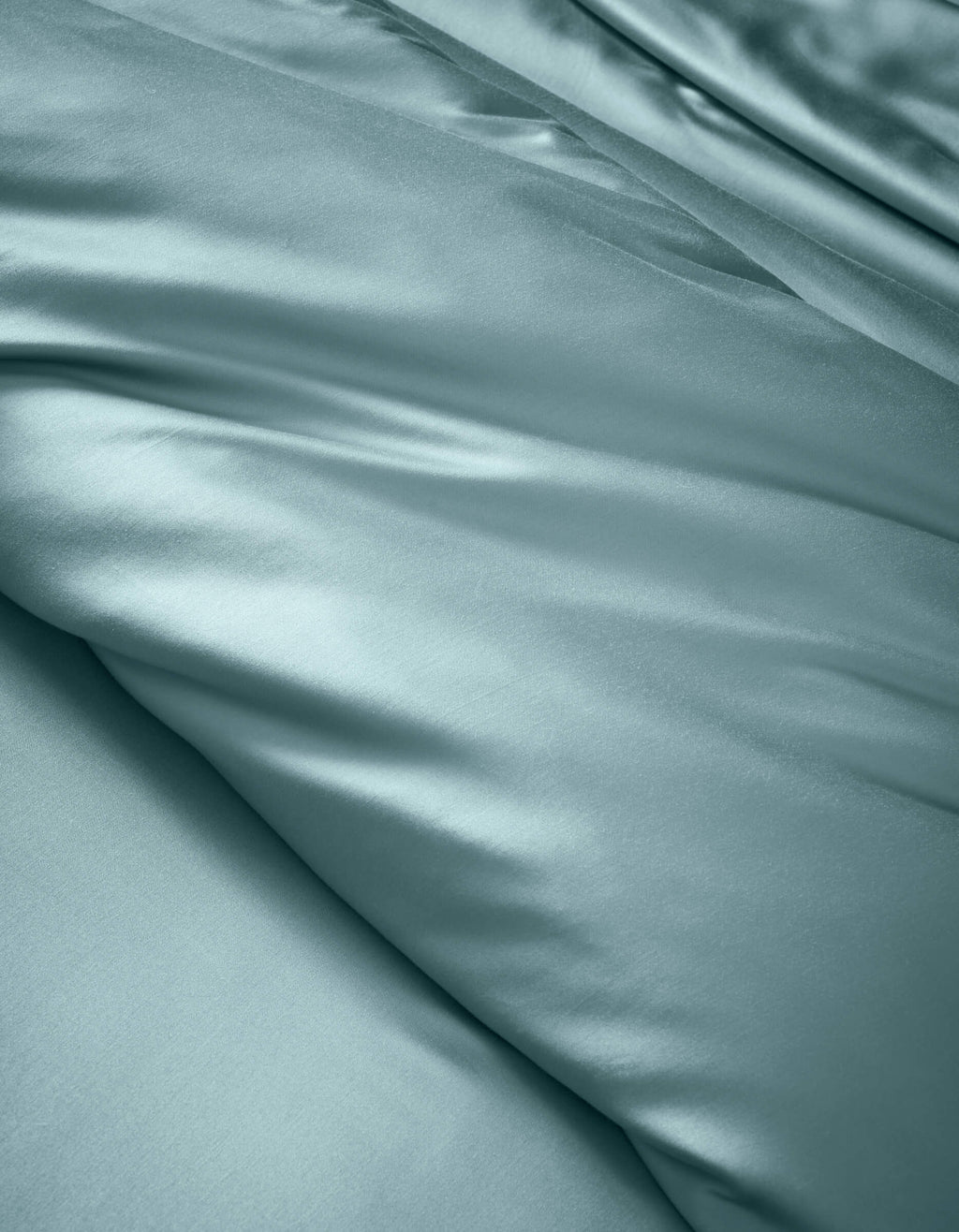 The Cozy Earth Bamboo Duvet Cover features smooth, light blue satin fabric with soft folds and a gentle sheen, offering a luxurious and elegant look.|Color:River