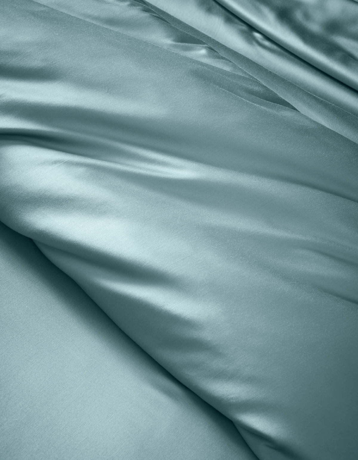 The Cozy Earth Bamboo Duvet Cover features smooth, light blue satin fabric with soft folds and a gentle sheen, offering a luxurious and elegant look.|Color:River