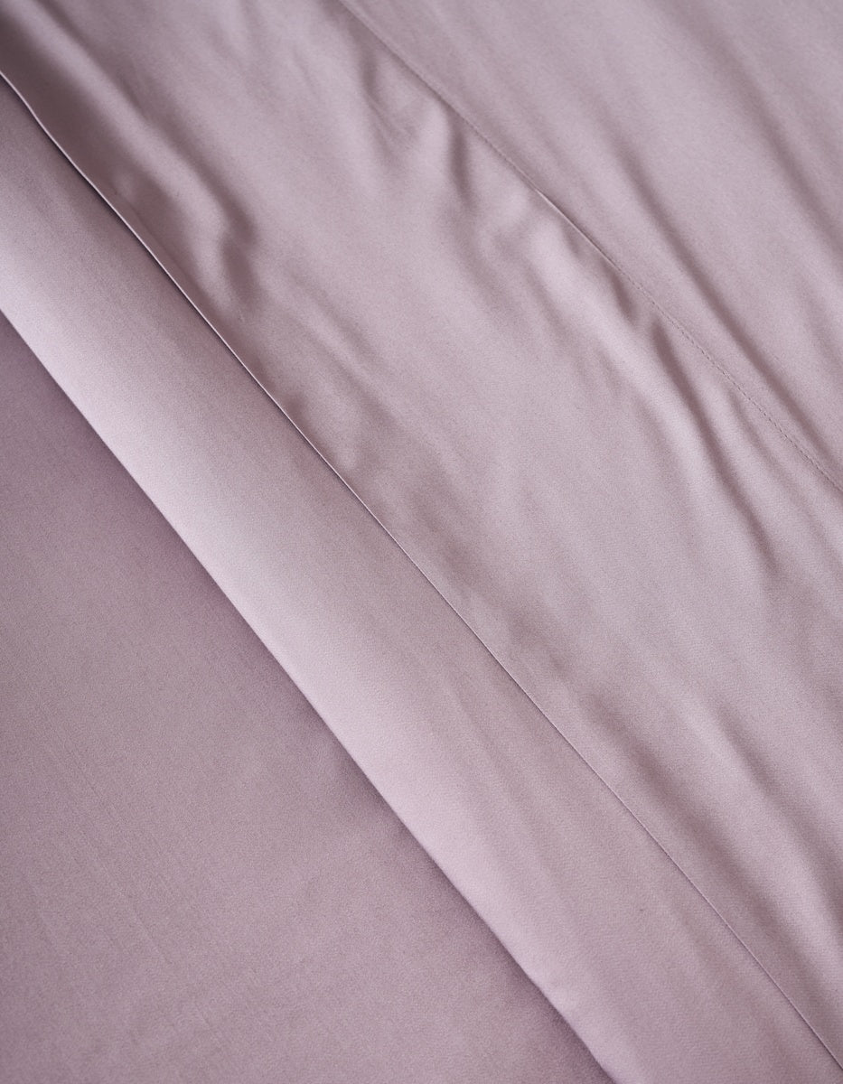 A close-up of the Cozy Earth Bamboo Duvet Cover in soft, light mauve shows visible folds and creases that create gentle shadows and enhance its textured appearance.|Color:Lavender