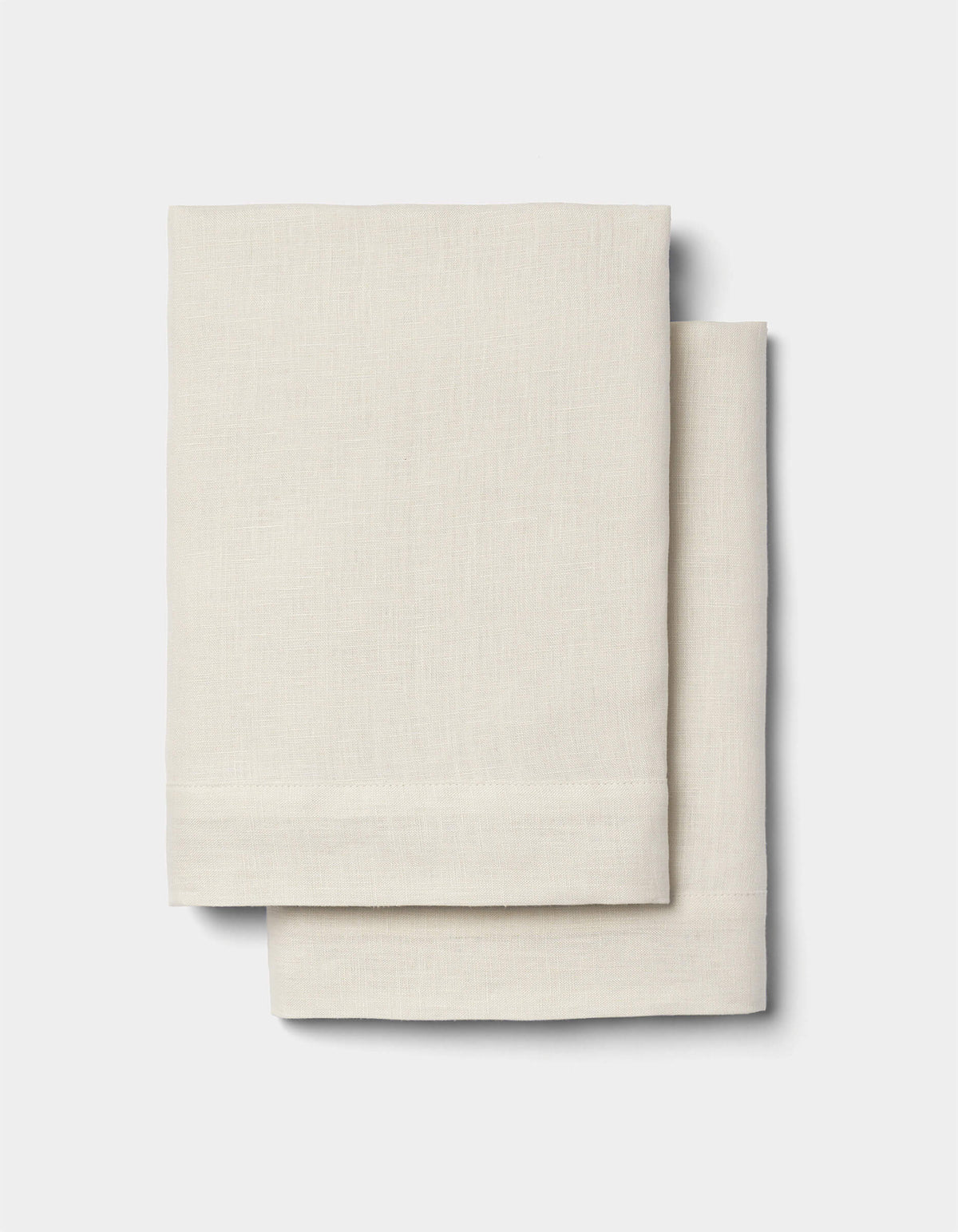 Two neatly folded Cozy Earth Linen Shams in light beige are stacked together against a plain white background.|Color:Flax